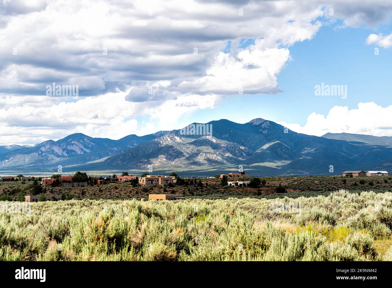 View grass green desert sage brush plants in Ranchos de Taos valley, New Mexico with Sangre de Cristo mountains landscape in summer Stock Photo
