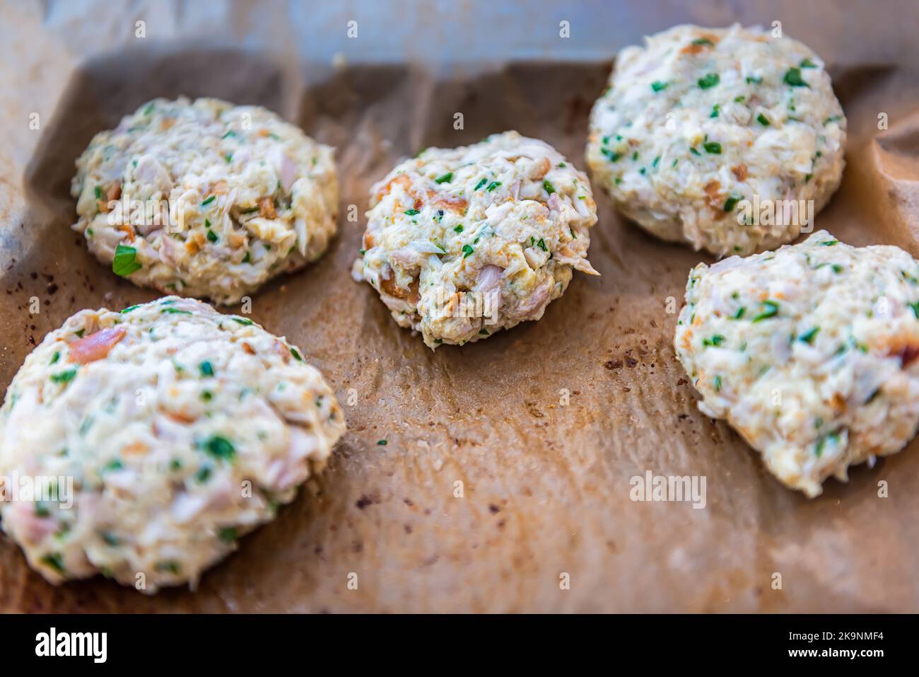 Macro closeup of raw uncooked crab crabmeat fish cakes on parchment