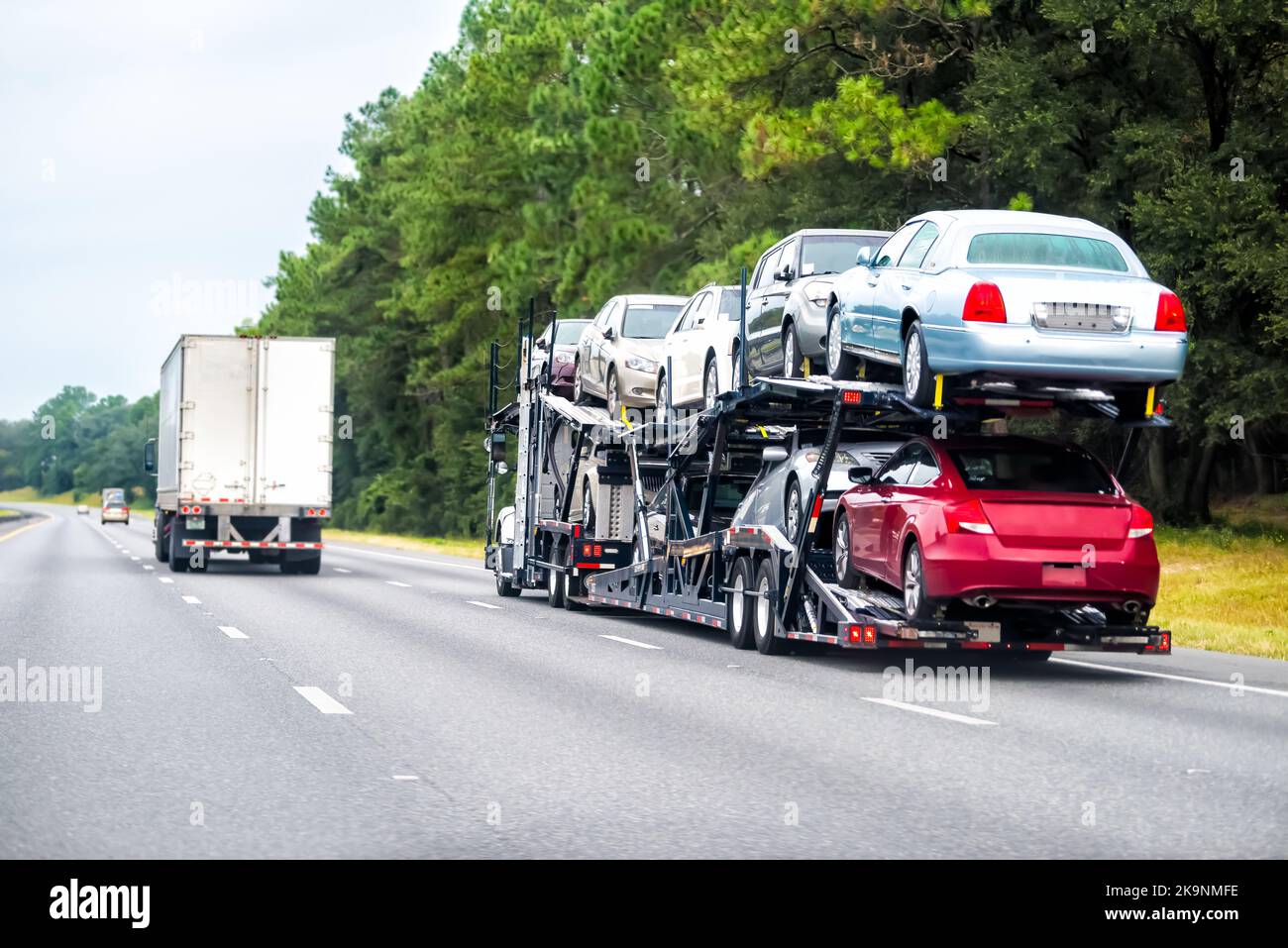 Truck trailer hauler transportation, commercial transport hauling brand new cars for auto dealership on Florida highway road Stock Photo