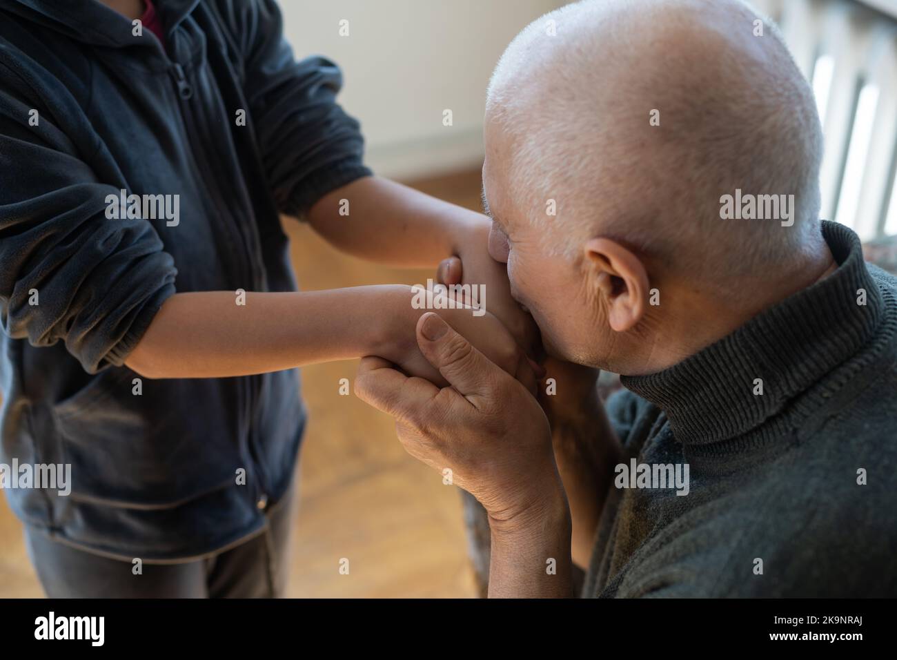 the hands of the child embracing a hand of the old man Stock Photo - Alamy