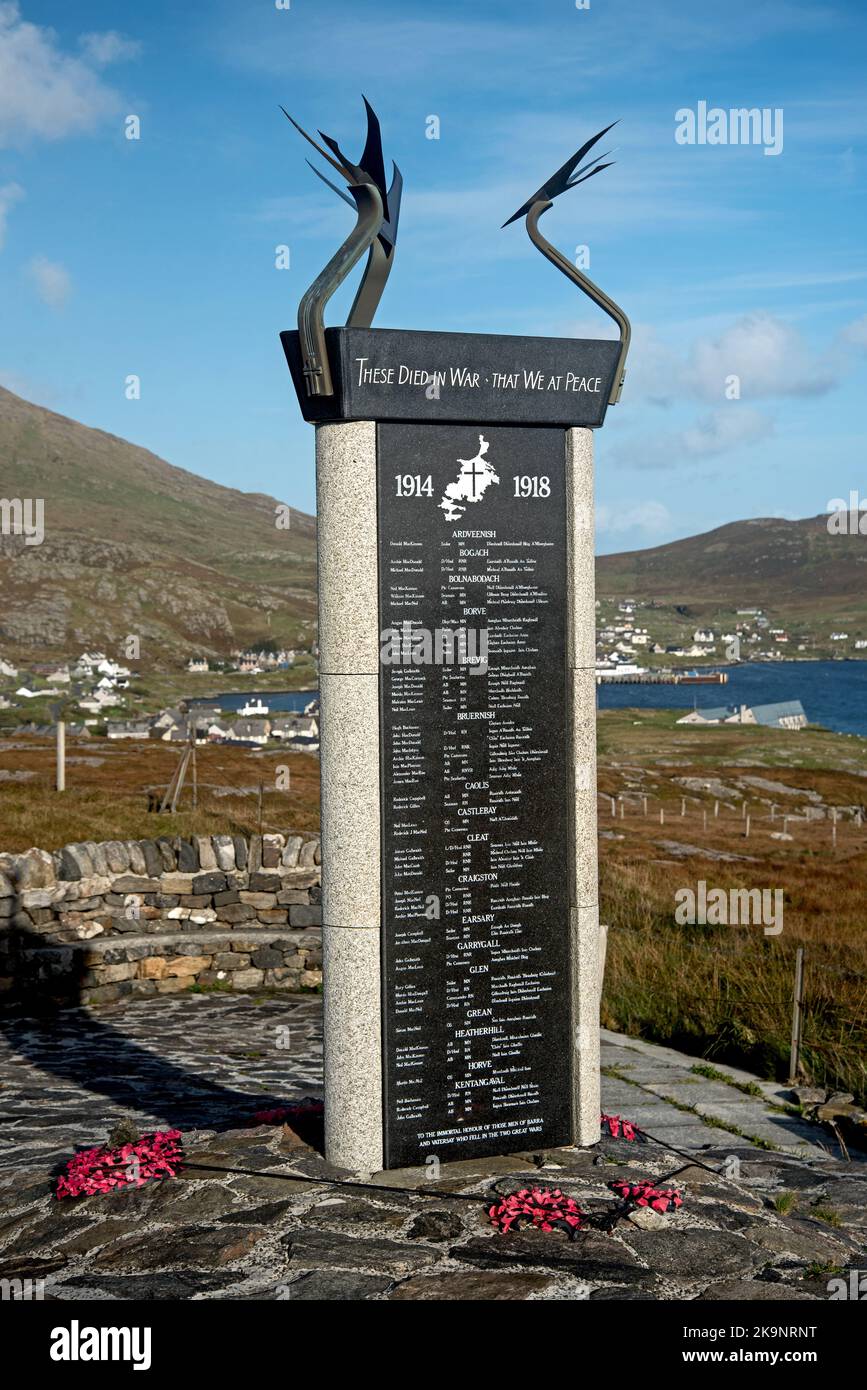 War memorial commemoraing residents of Barra and Vatersay who died in World War One and Two at Nasg on the Isle of Barra  with views to Castlebay. Stock Photo