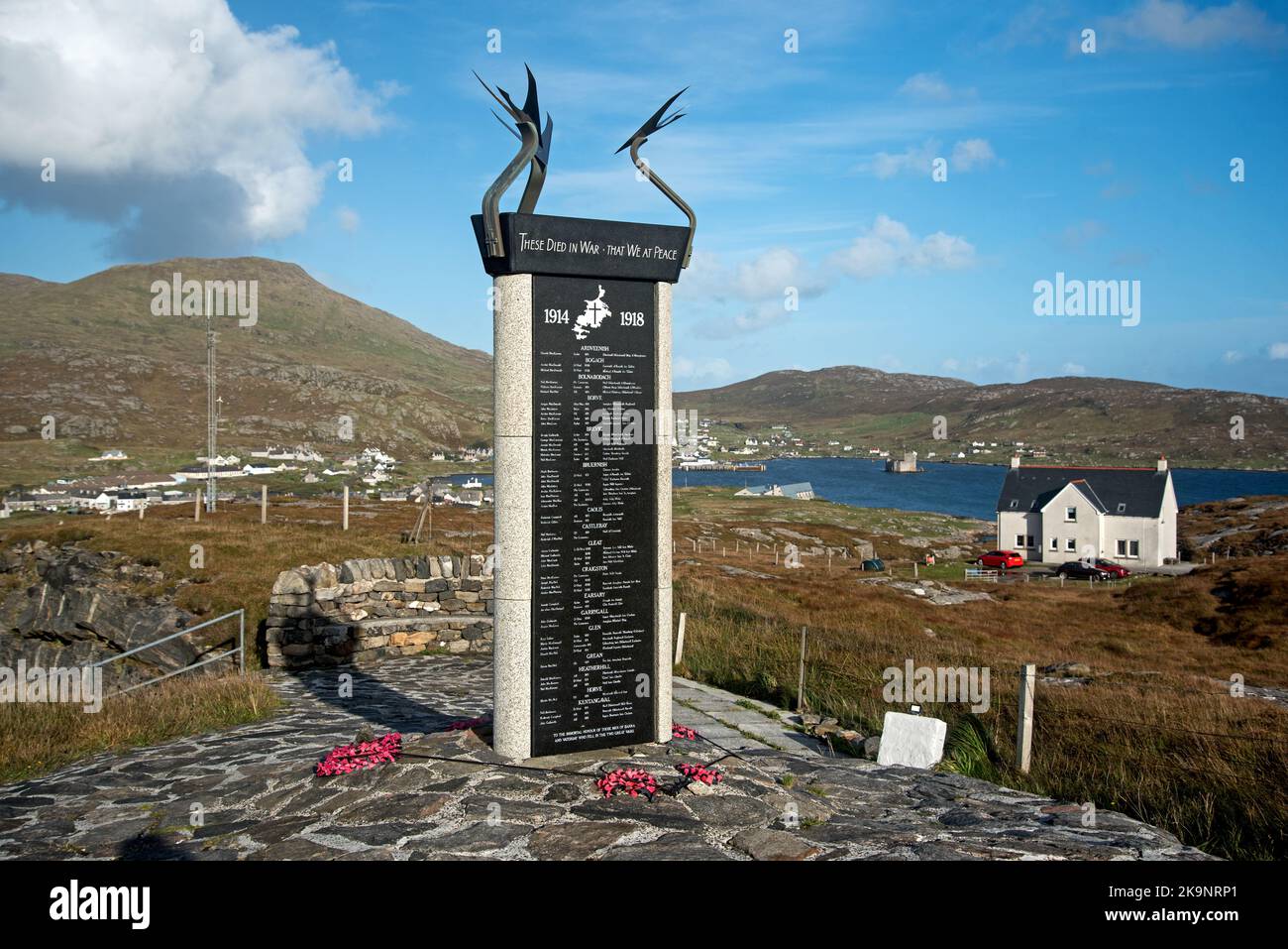 War memorial commemoraing residents of Barra and Vatersay who died in World War One and Two at Nasg on the Isle of Barra  with views to Castlebay. Stock Photo