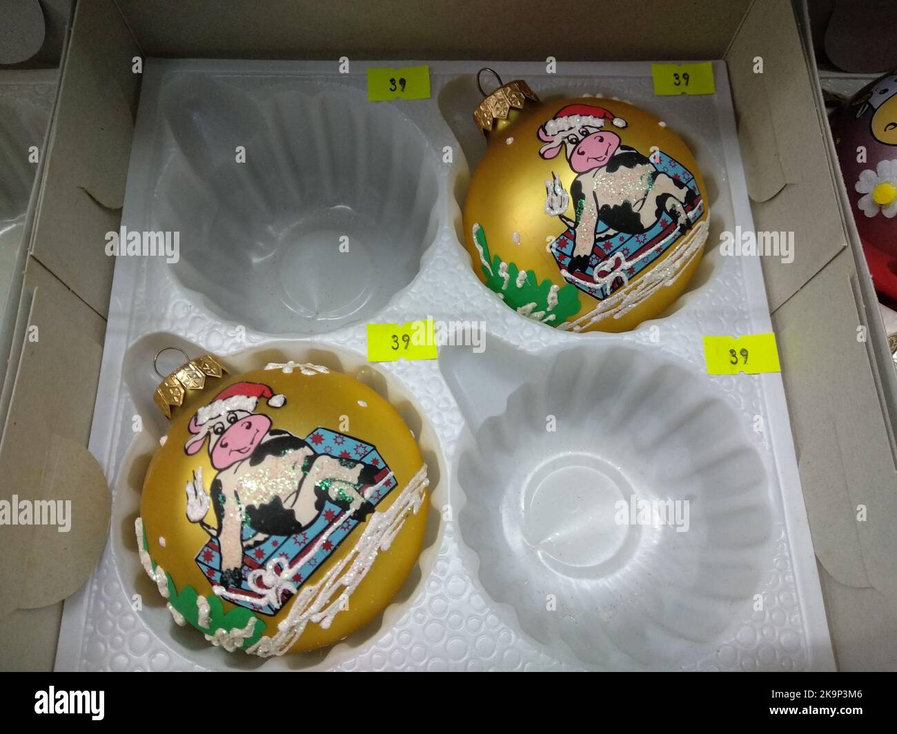 New Year's souvenirs in a box, round colored balls on a Christmas tree with the symbol of the year bull Stock Photo