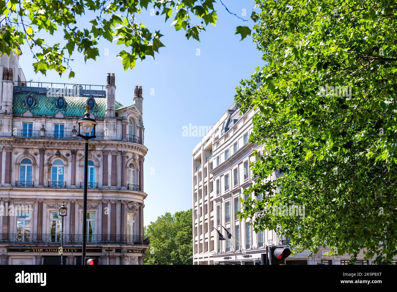 London, United Kingdom - June 22, 2018: Framing view of green trees foliage on Trafalgar square, Cockspur street with Admiralty pub, rooftop hotel Stock Photo