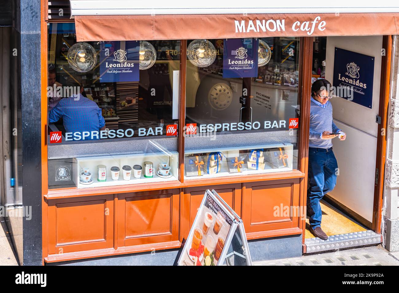 London, United Kingdom - June 22, 2018: Manon cafe restaurant bakery serving Leonidas fresh belgian hot chocolate with businessman on Fleet Street Stock Photo