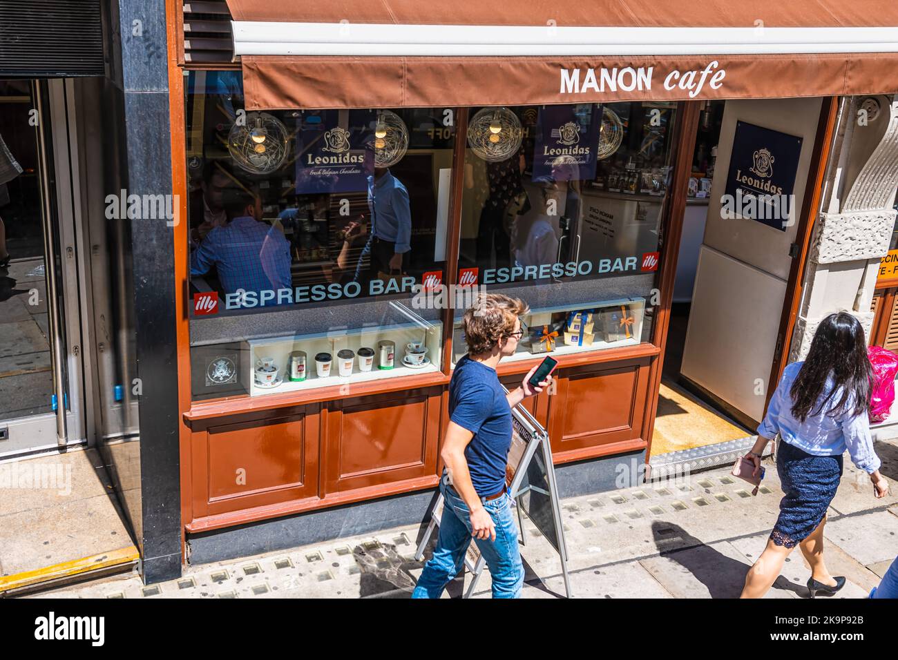 London, United Kingdom - June 22, 2018: Manon cafe restaurant bakery serving Leonidas fresh belgian hot chocolate with people on Fleet Street Stock Photo