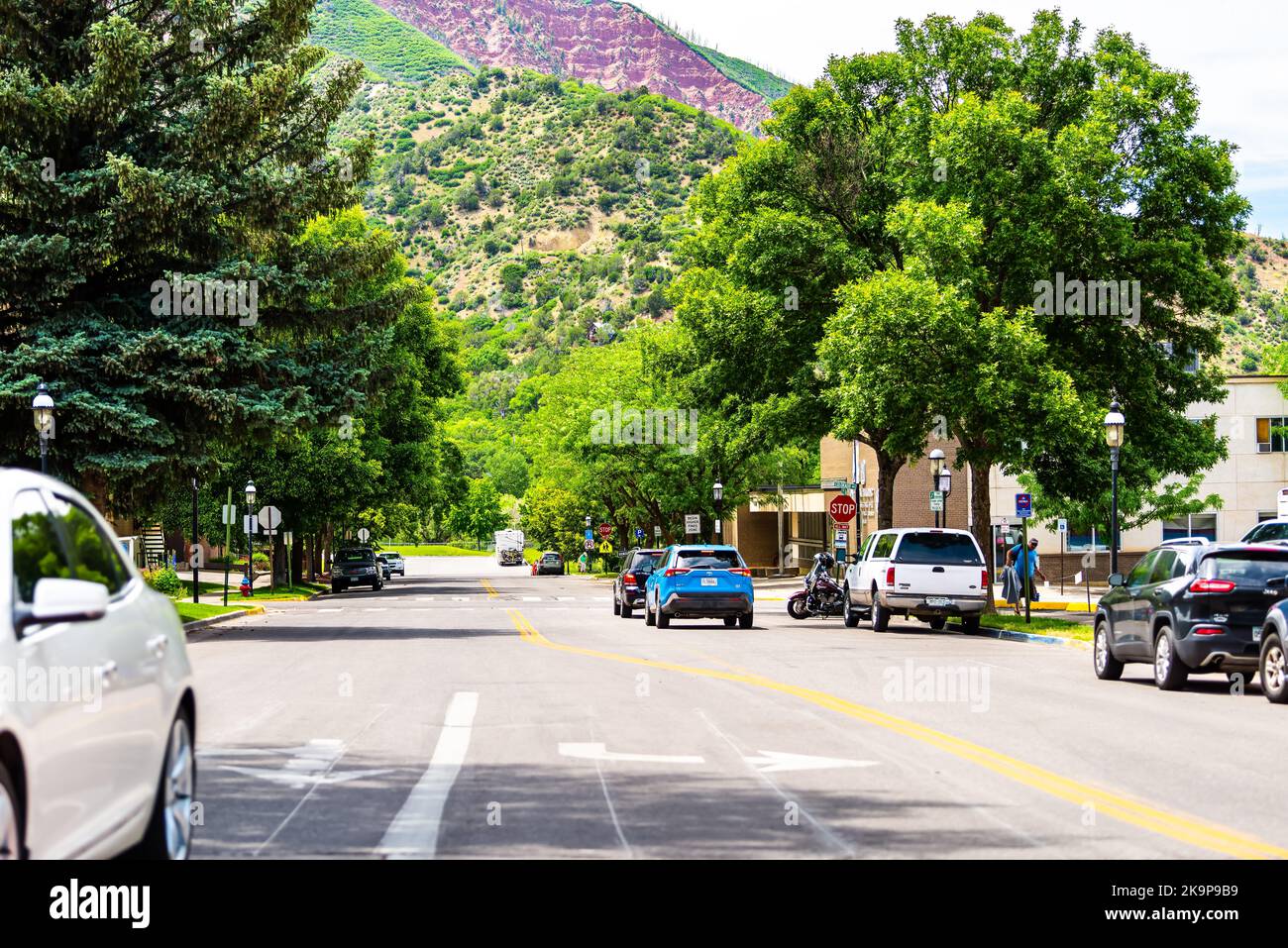 Glenwood Springs, USA - June 29, 2019: Downtown city with residential street road in Colorado and people walking by cars near Red mountain Stock Photo