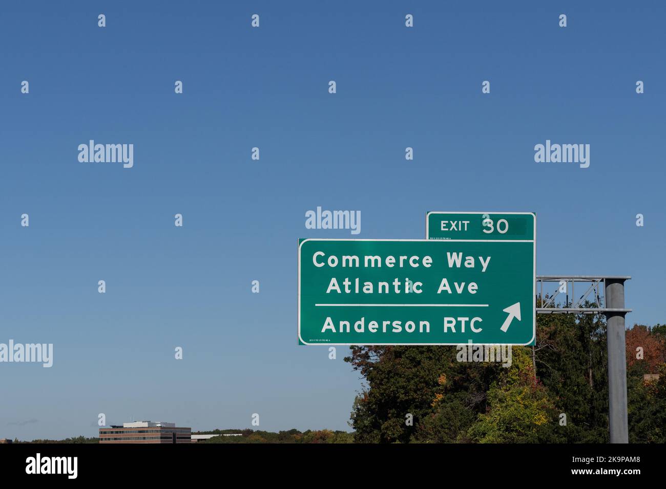 Highway sign on Route 93 Northbound in Reading, Massachusetts: Exit 30 Commerce Way, Atlantic Ave, and Anderson RTC Stock Photo