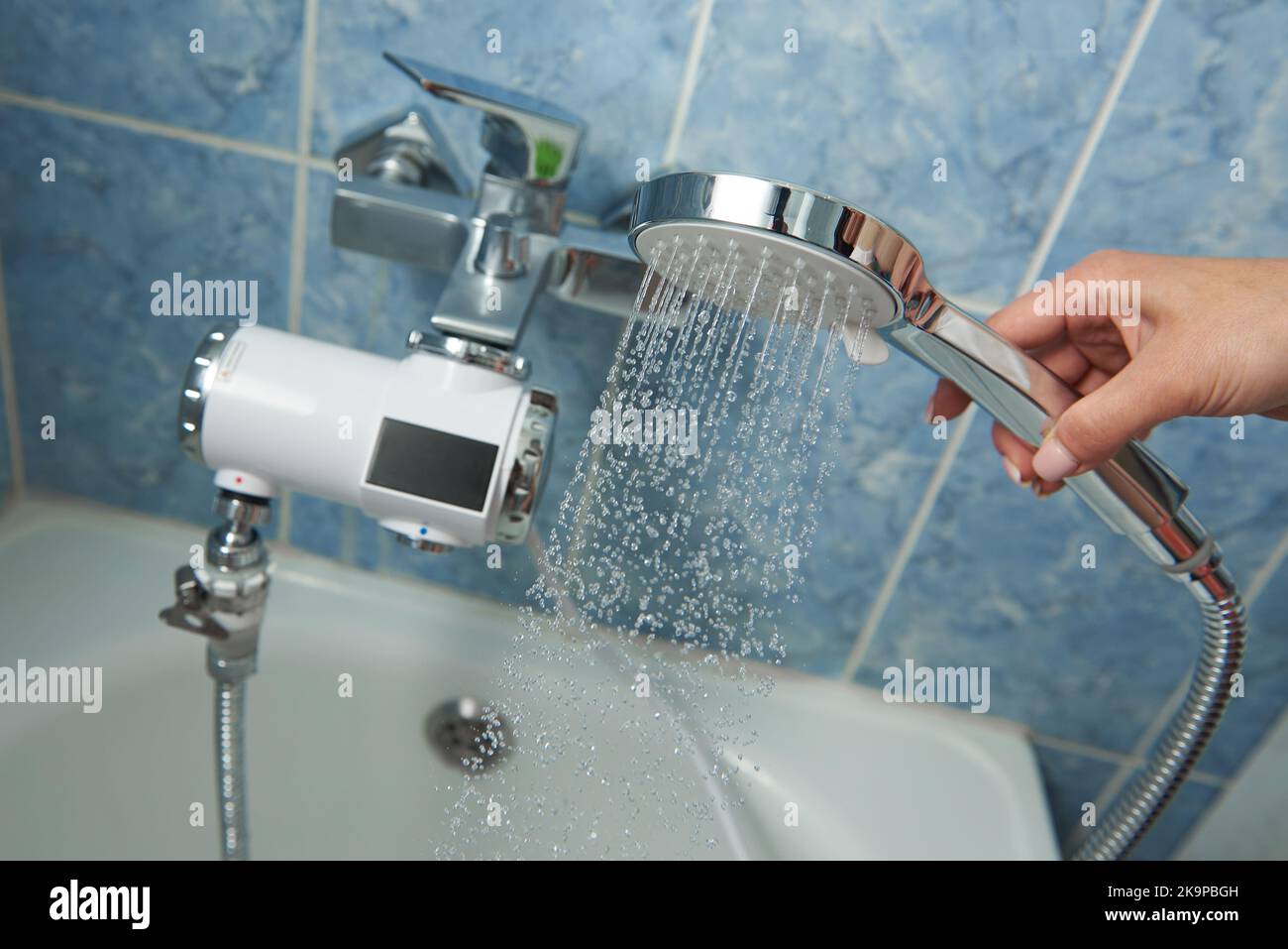 Shower with electric water heater in the bathroom. Stock Photo