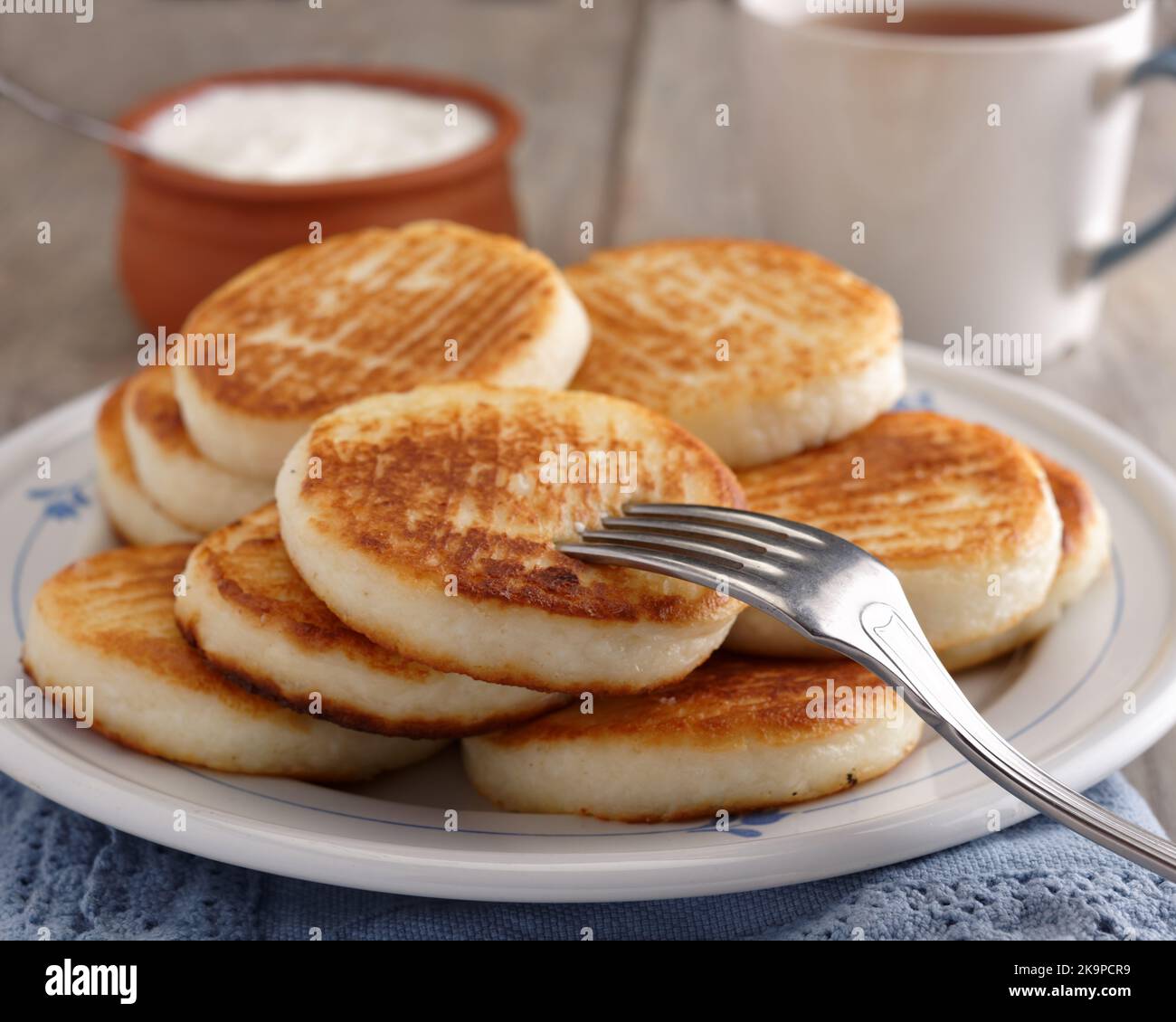 Syrniki, the traditional Russian cheese pancakes on a rustic table Stock Photo