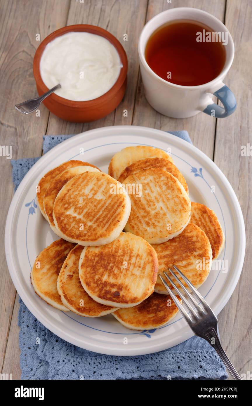 Syrniki, the traditional Russian cheese pancakes on a rustic table Stock Photo