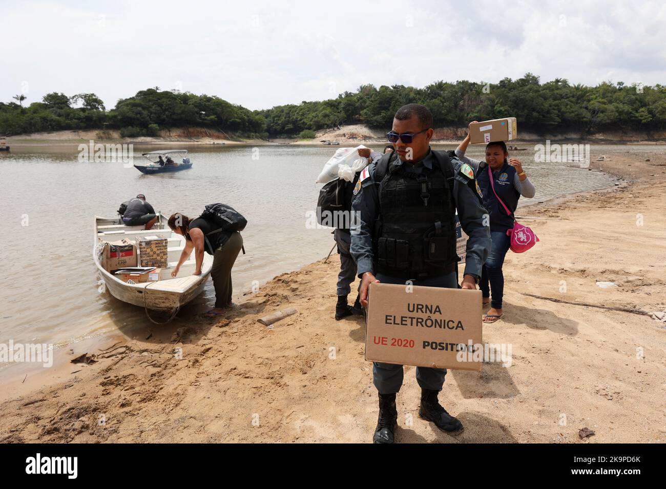 Employees from the Regional Electoral Court (TRE) and military police officers transport electronic ballot boxes to voting stations in the community of 'ribeirinhos' (forest dwellers) Bela Vista do Jaraqui, ahead of Brazilian elections, in Manaus, Brazil October 29, 2022. REUTERS/Bruno Kelly Stock Photo