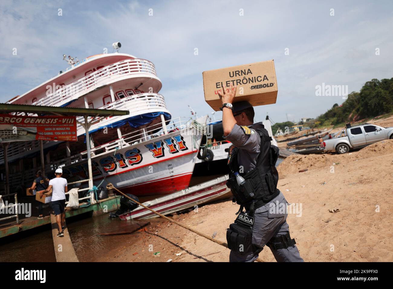 A police officer carries an electronic ballot box to voting polling stations of a community of 'ribeirinhos' (forest dwellers), ahead of Brazilian elections, in Sao Raimundo Port, in Manaus, Brazil October 29, 2022. REUTERS/Bruno Kelly Stock Photo