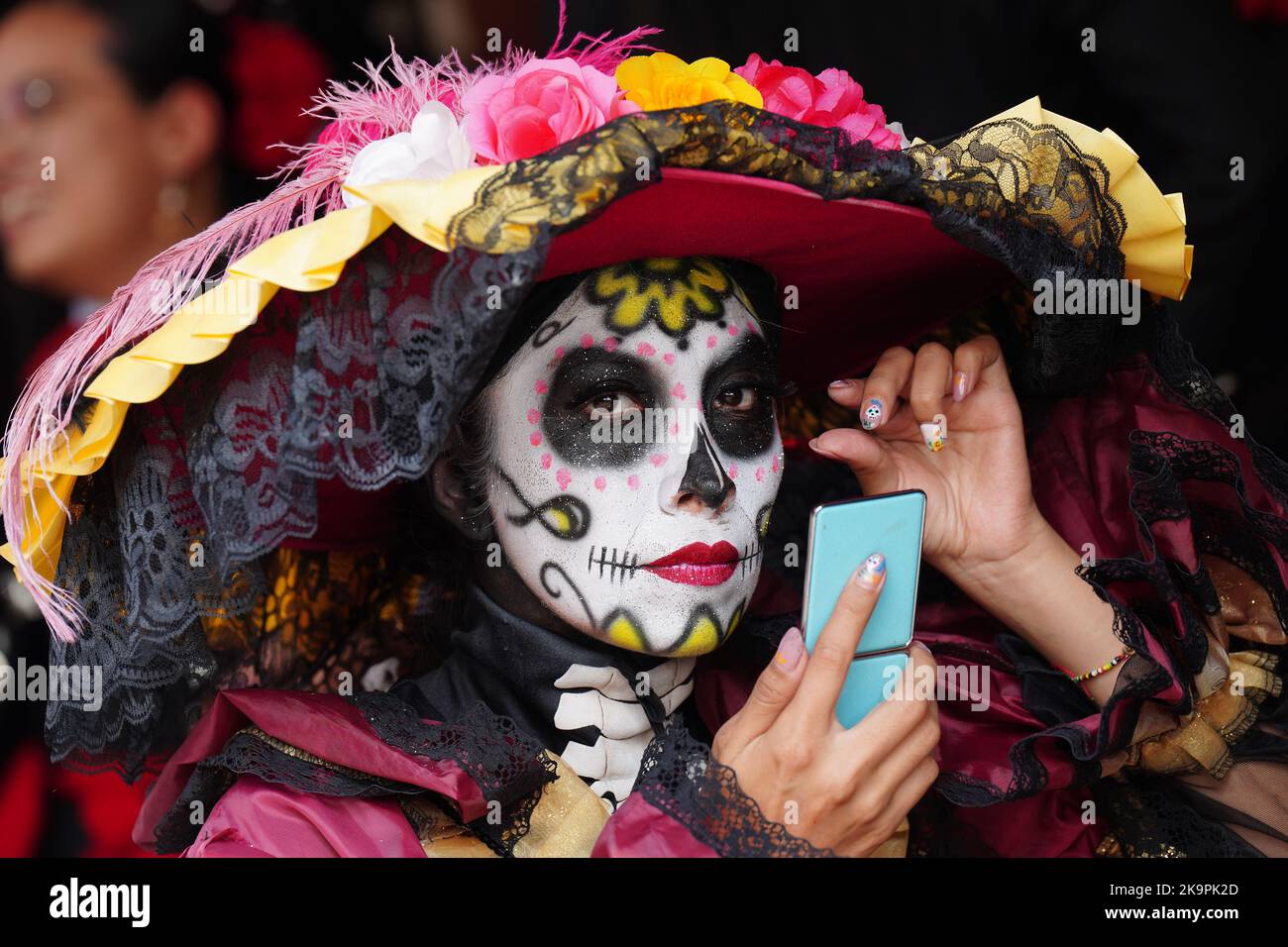 Mexico City, Mexico. 29th Oct, 2022. A woman dressed in the costume of Catrina, the skeleton bride, prepares her makeup before the start of the Grand Parade of the Dead to celebrate Dia de los Muertos holiday on Paseo de la Reforma, October 29, 2022 in Mexico City, Mexico. Credit: Richard Ellis/Richard Ellis/Alamy Live News Stock Photo