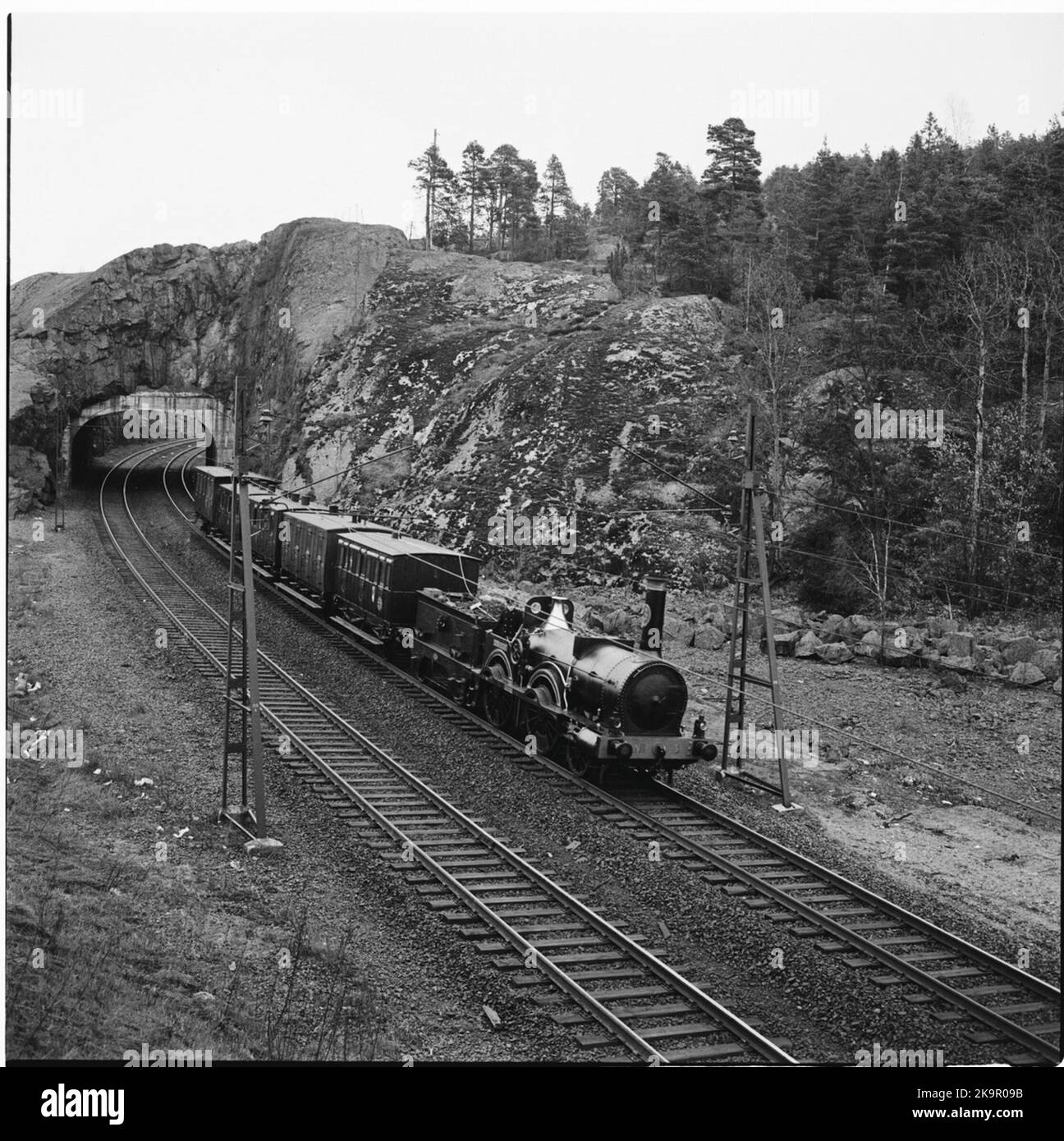 The historic train passes the tunnel just west of the view above the innermost part of Tullingesjön. Travel from Stockholm to Gothenburg for the inauguration of train 62. SJ B 3 'Prince August'. KHJ CD 13. SJ C 182. SJ AB 289. SJ A 103. SJ C2B 329. Stock Photo