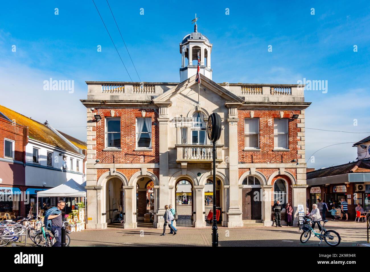 The Old Town Hall on High Street, Christchurch in Dorset, UK with stone pillars and a red brick facade. Stock Photo