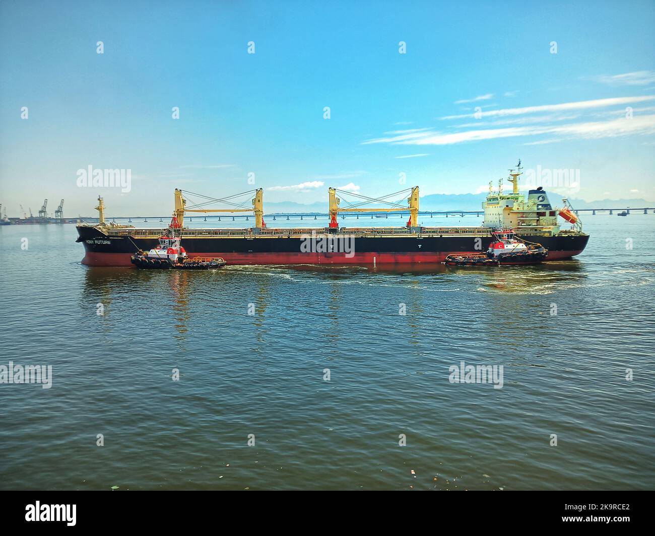 cargo ship with crane,cargo ship and tug boats,tugs pushing big ship