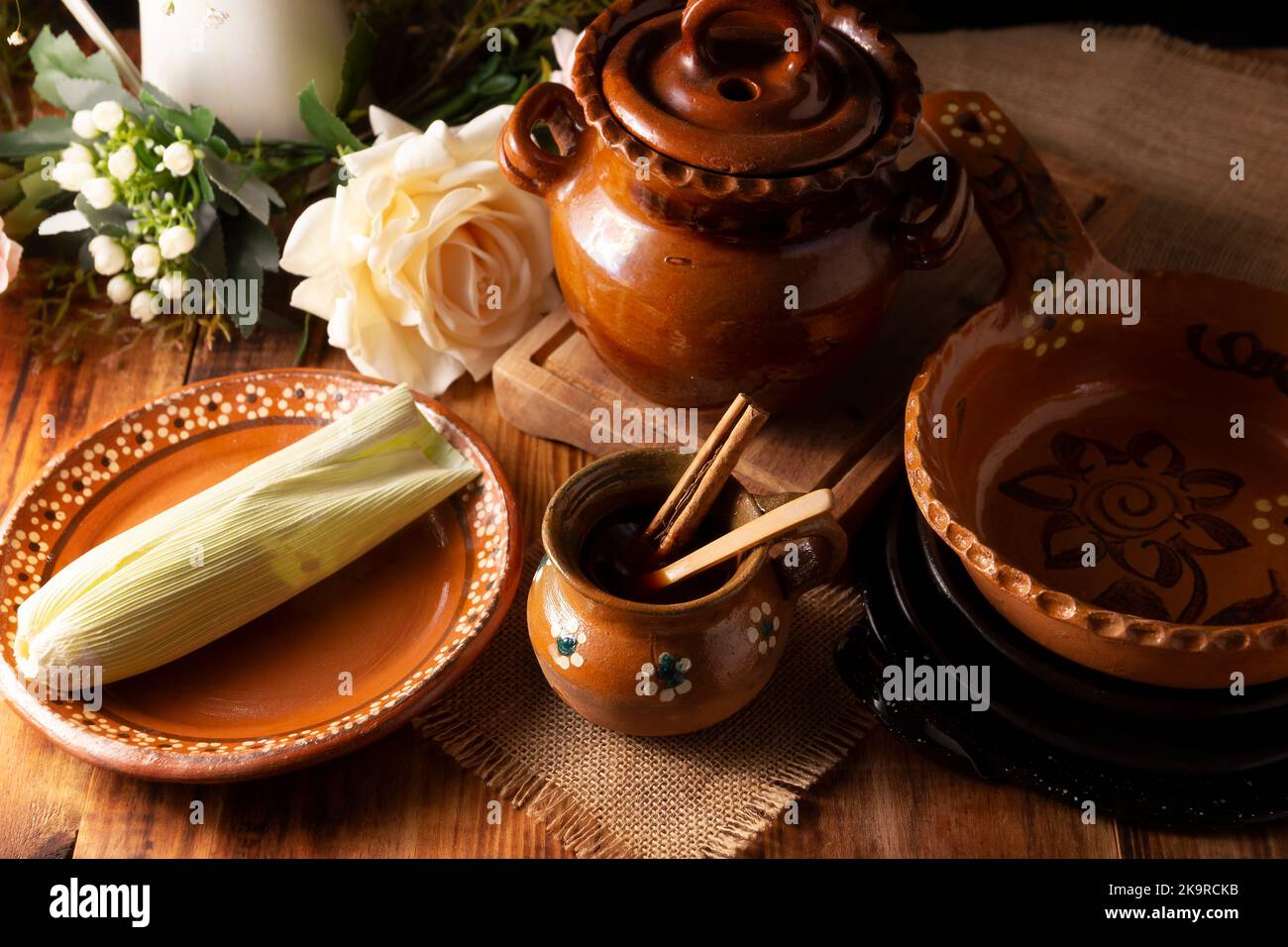 Authentic homemade mexican coffee (cafe de olla) and tamal served in traditional handmade clay mug (Jarrito de barro) on rustic wooden table. Stock Photo