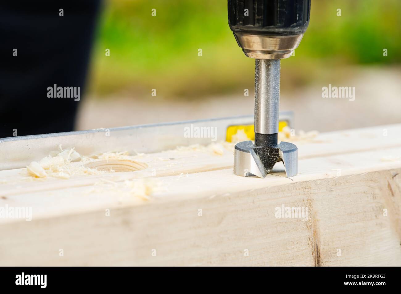 Carpenter drilling holes in the wood beam. wooden frame domestic house