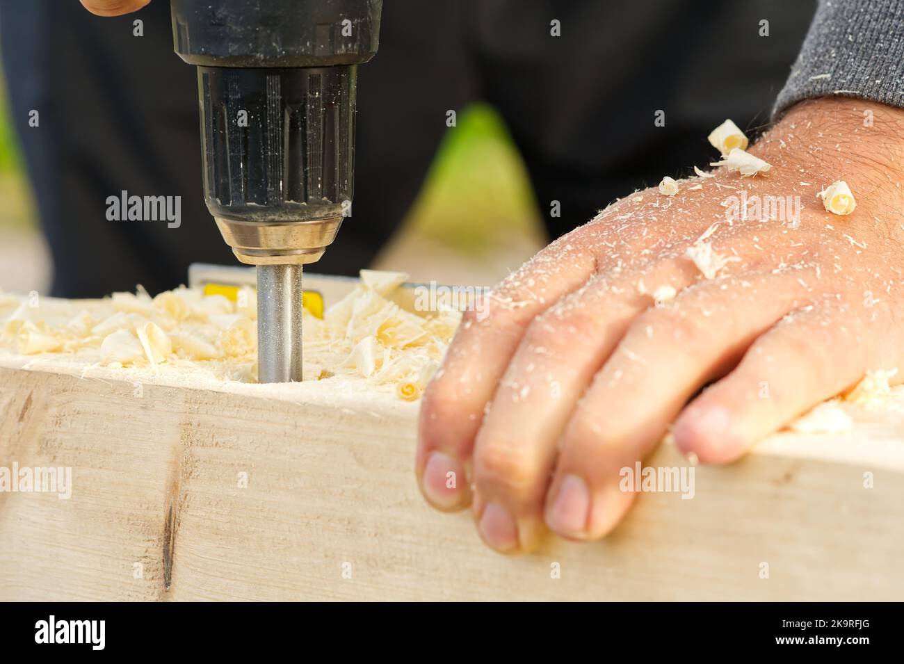 Carpenter drilling holes in the wood beam. wooden frame domestic house