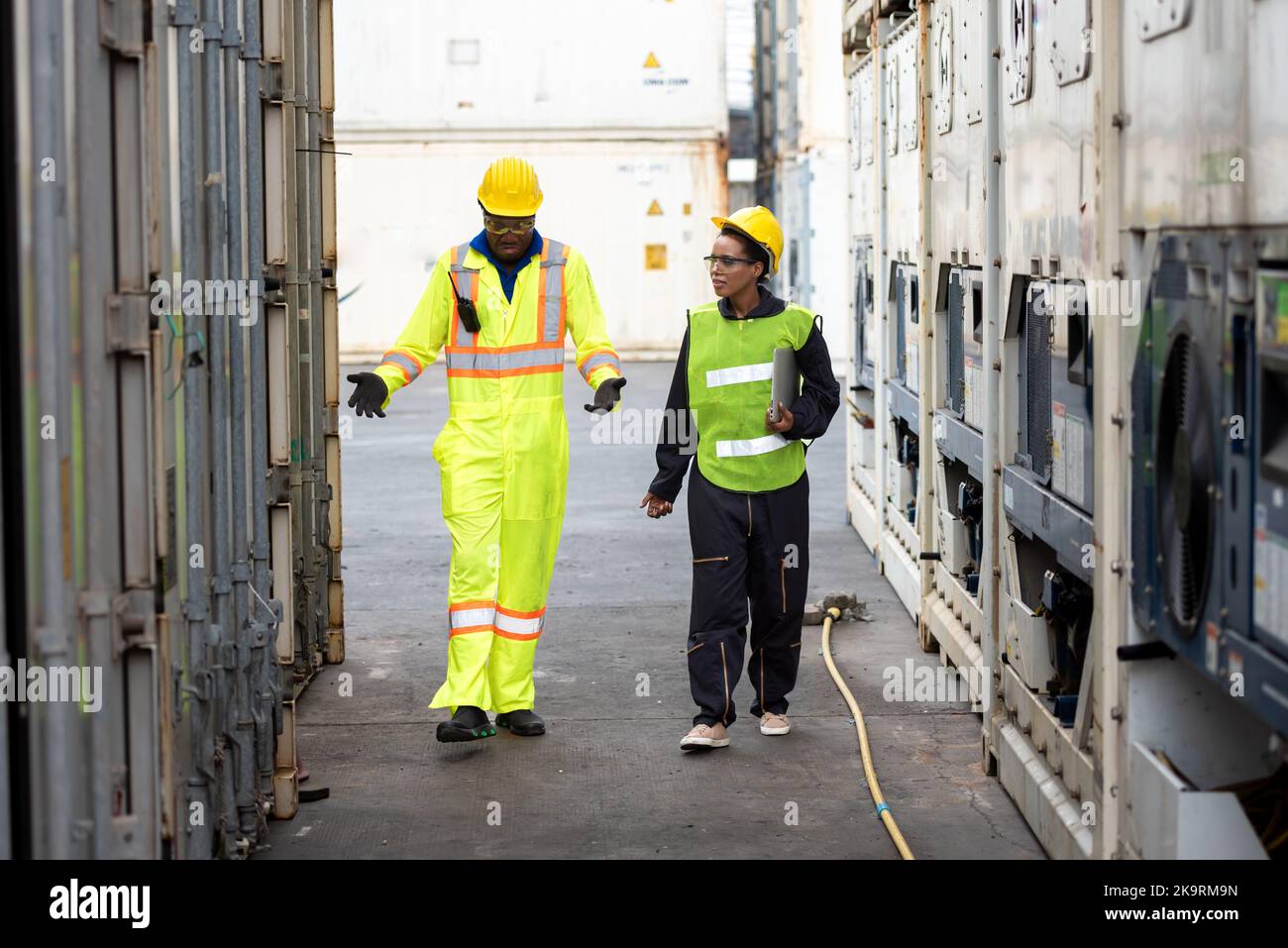 Young worker people working job at a warehouse,  Industrial Engineers, Safety Supervisors and Foremen in Hard Hats and Safety Vests Walking in Shippin Stock Photo