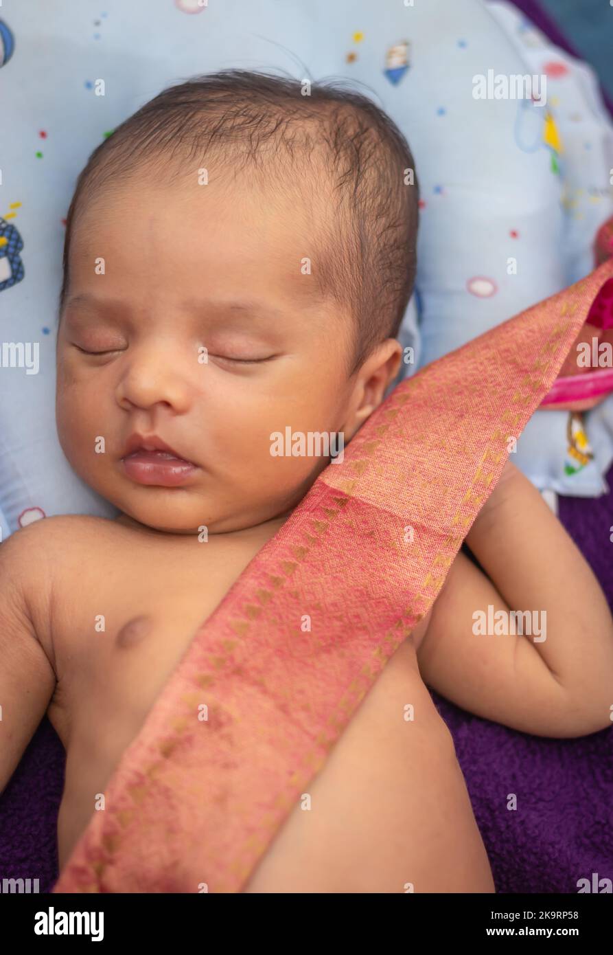 cute newborn baby sleeping in baby wrap top angle shot Stock Photo