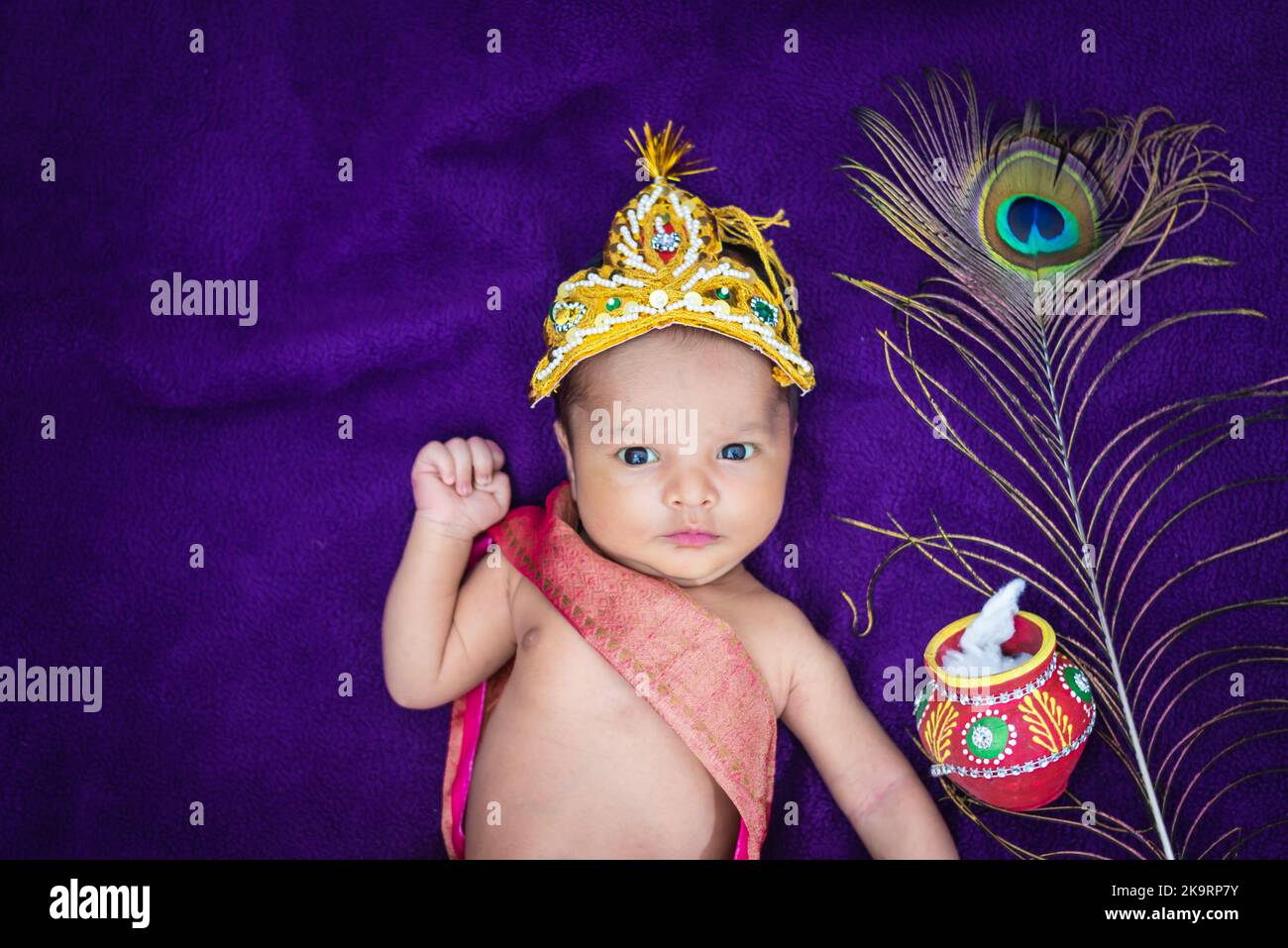 newborn baby boy in krishna dressed with props from unique perspective