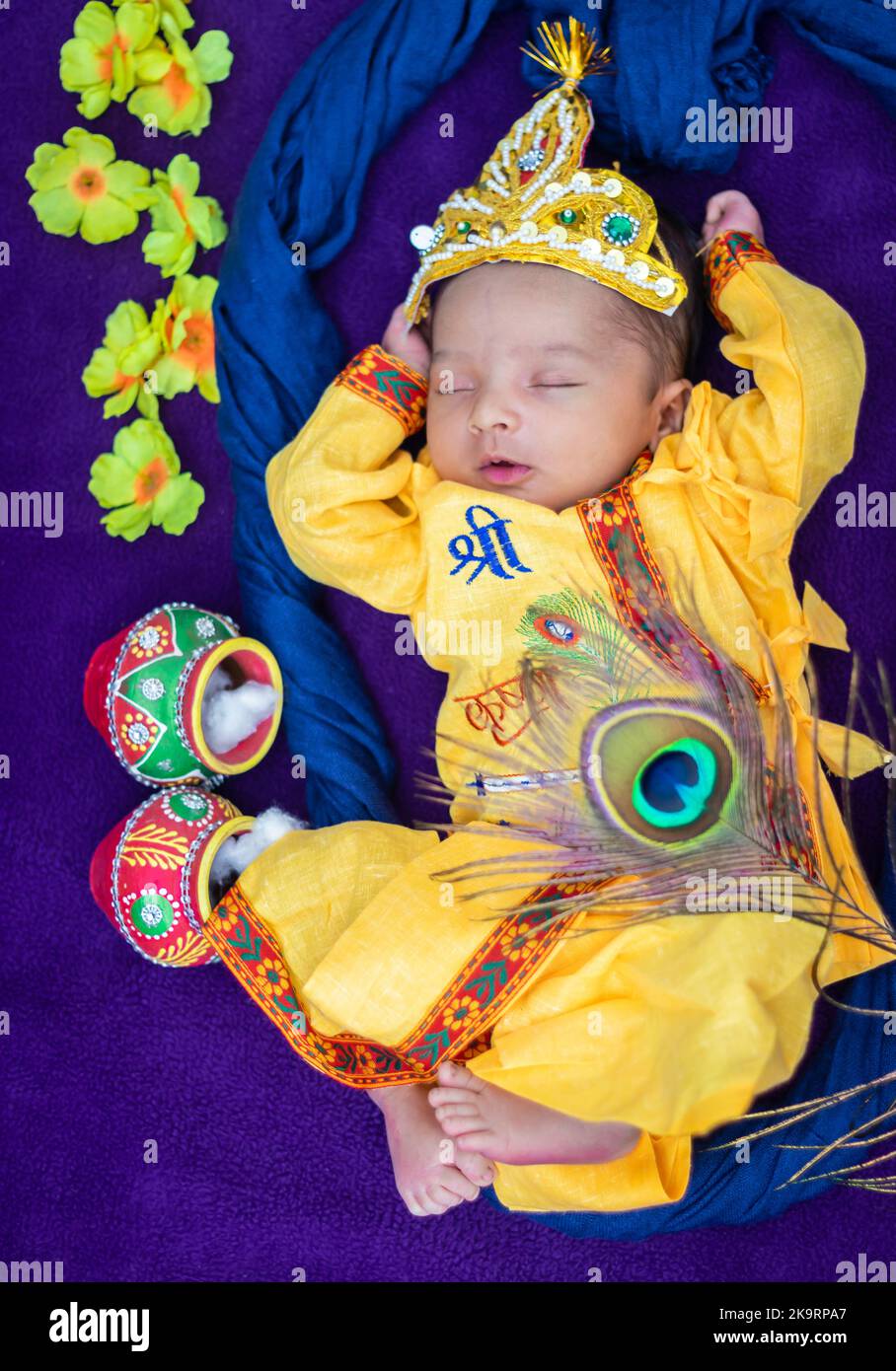 newborn baby boy in krishna dressed with props from unique perspective