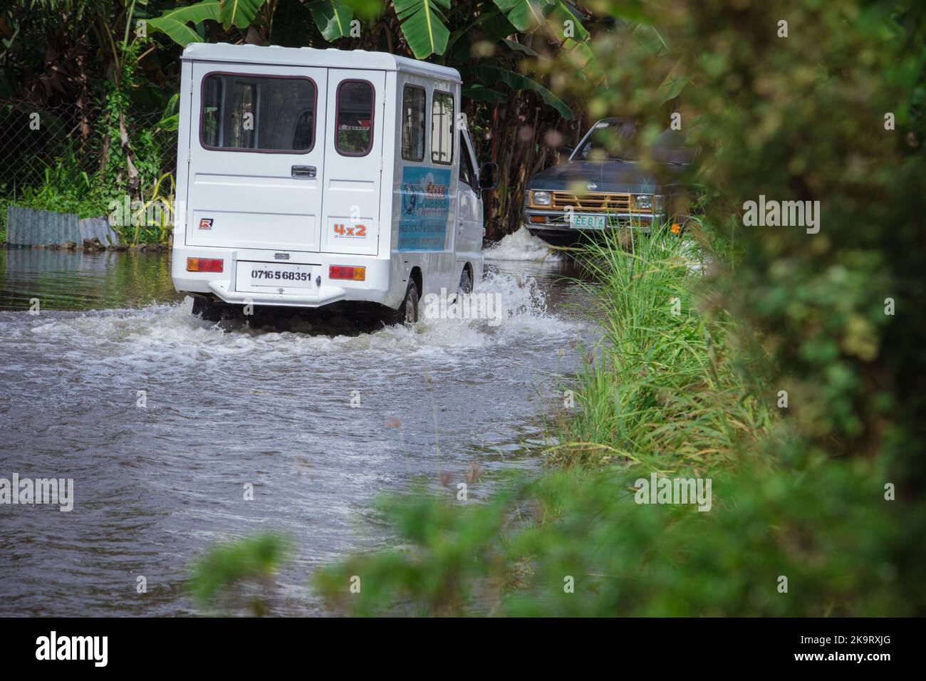 Severe tropical storm Paeng or Nalgae brought flashfloods and rain to the country. Van travelling on flooded road. Relief operation. Stock Photo
