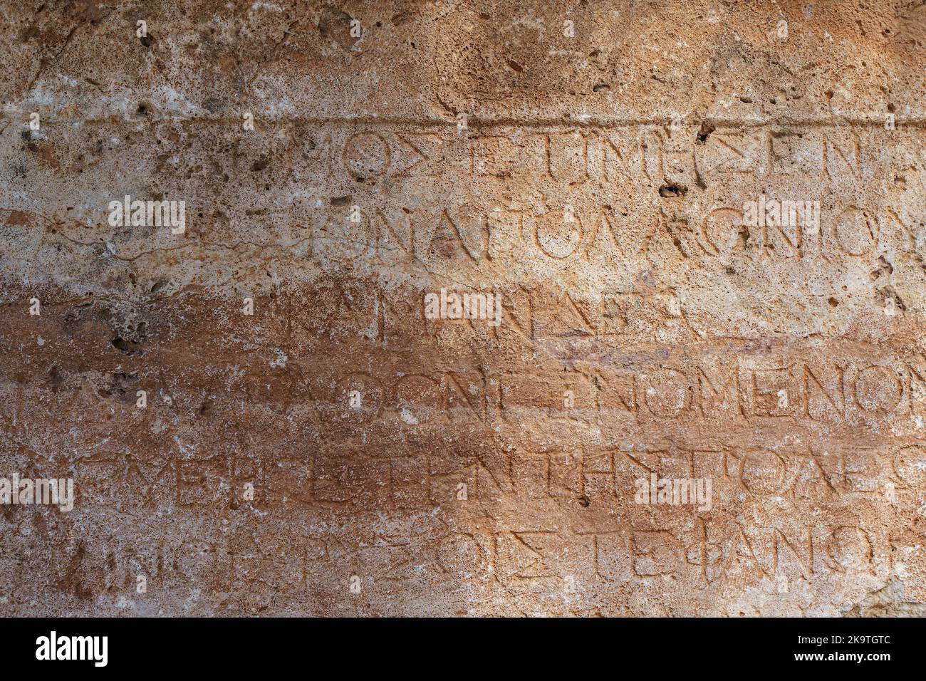 Ancient Greek antique text and inscriptions on the stone wall of the temple. Ancient Greek culture, alphabet and writing background, history concept. High quality photo Stock Photo