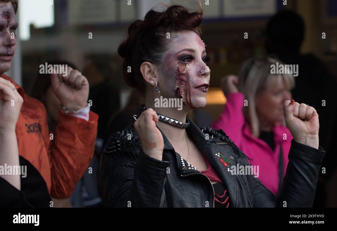 Terrifying Halloween flash mob arrive outside Eastbourne's famous pier to dance to amused, surprised and a little scared tourists and passers by Stock Photo