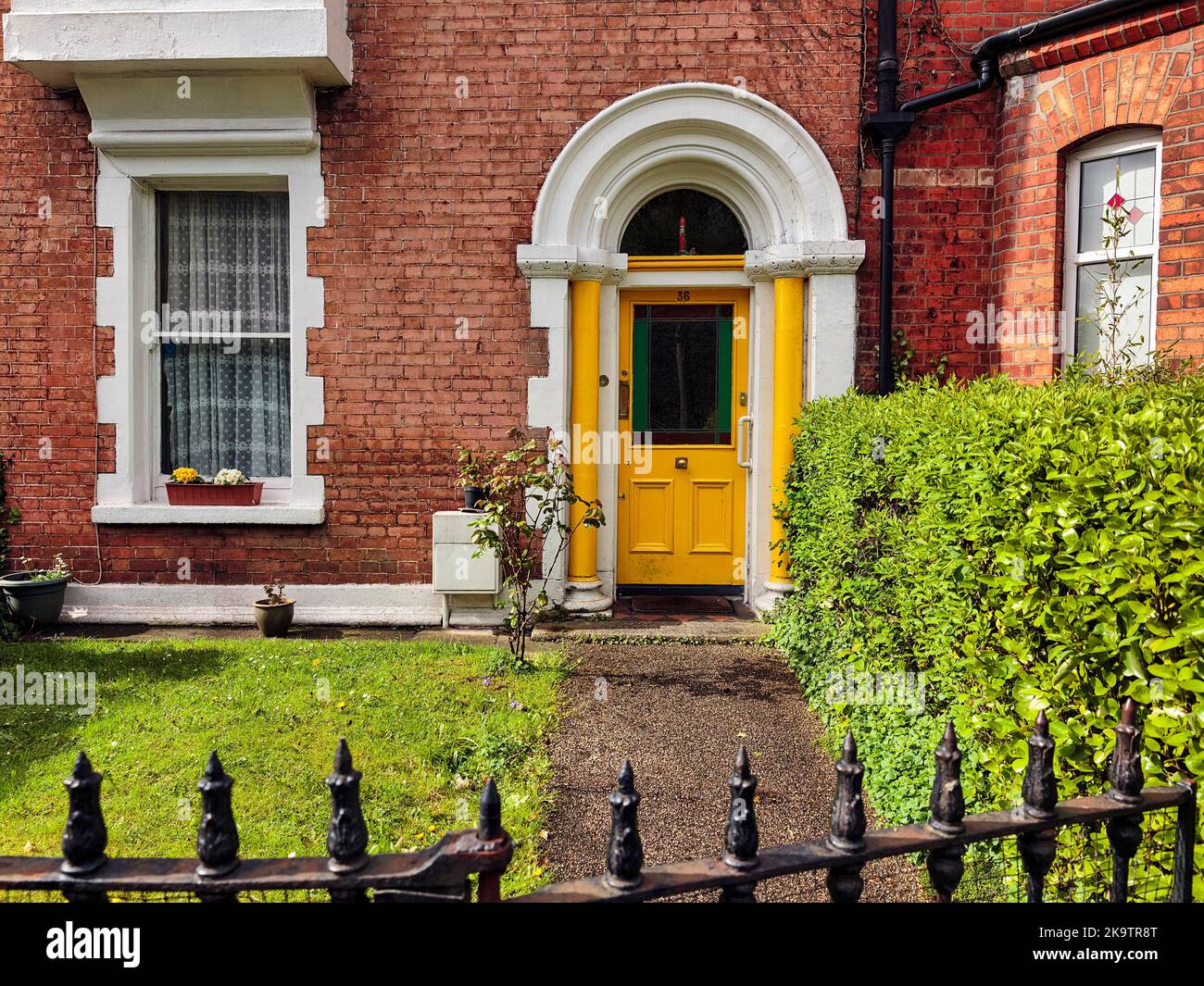 Typical terraced house with small front garden, yellow door, Dublin
