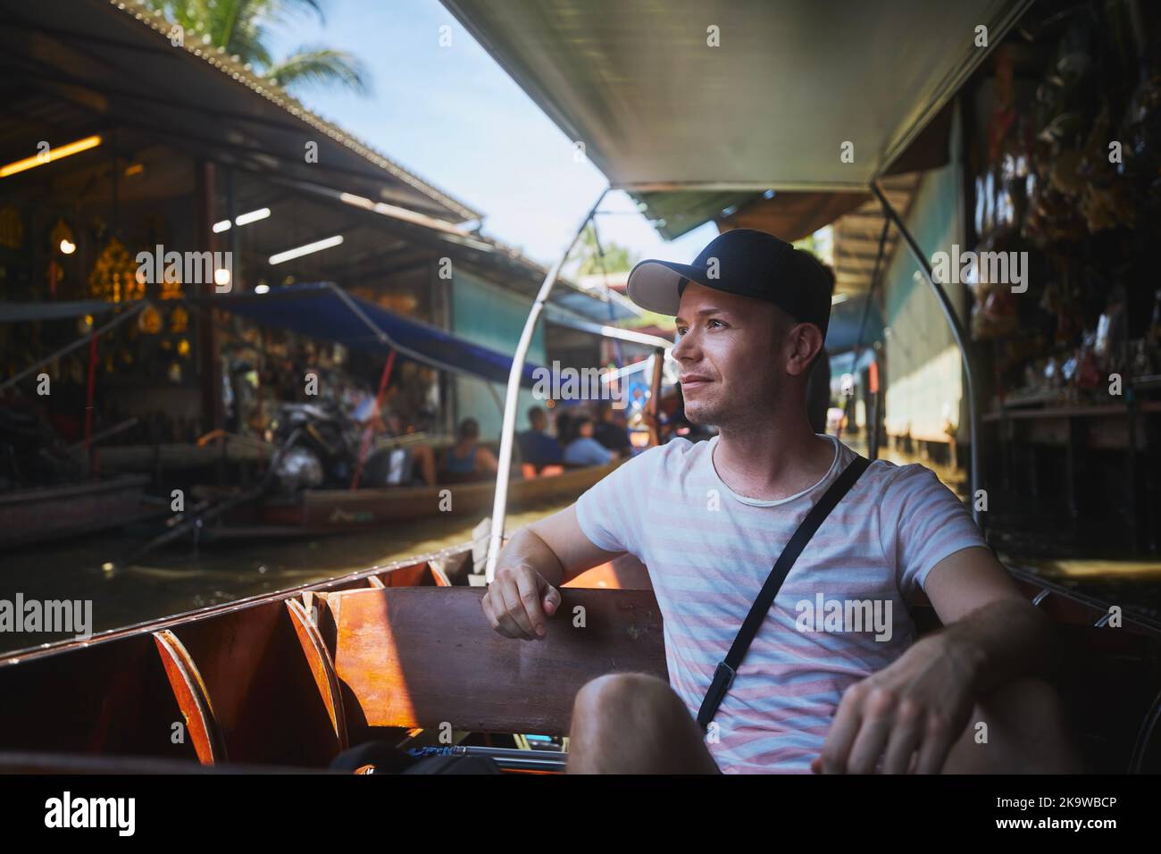 Tourist on boat. Man enjoys trip to floating market Damnoen Saduak in Ratchaburi near Bangkok, Thailand. Stock Photo
