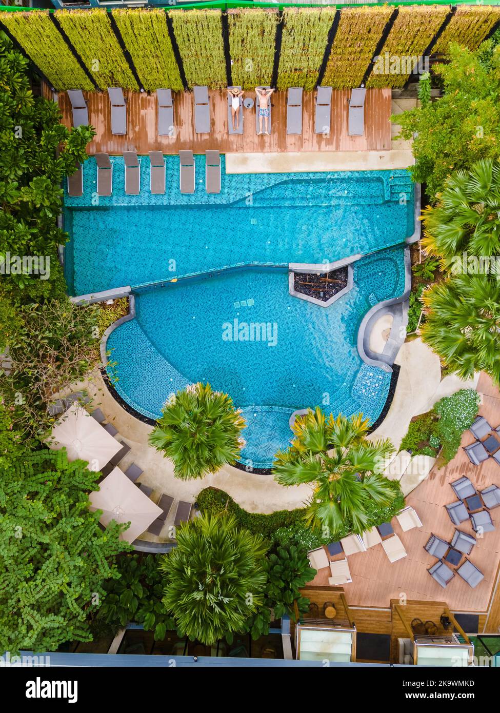 Drone view from above at the swimming pool. Couple men and women in ...