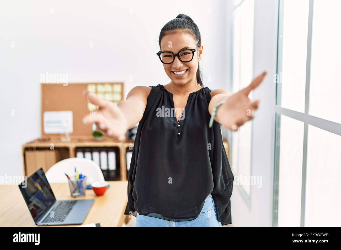 Young hispanic business woman working at the office looking at the ...