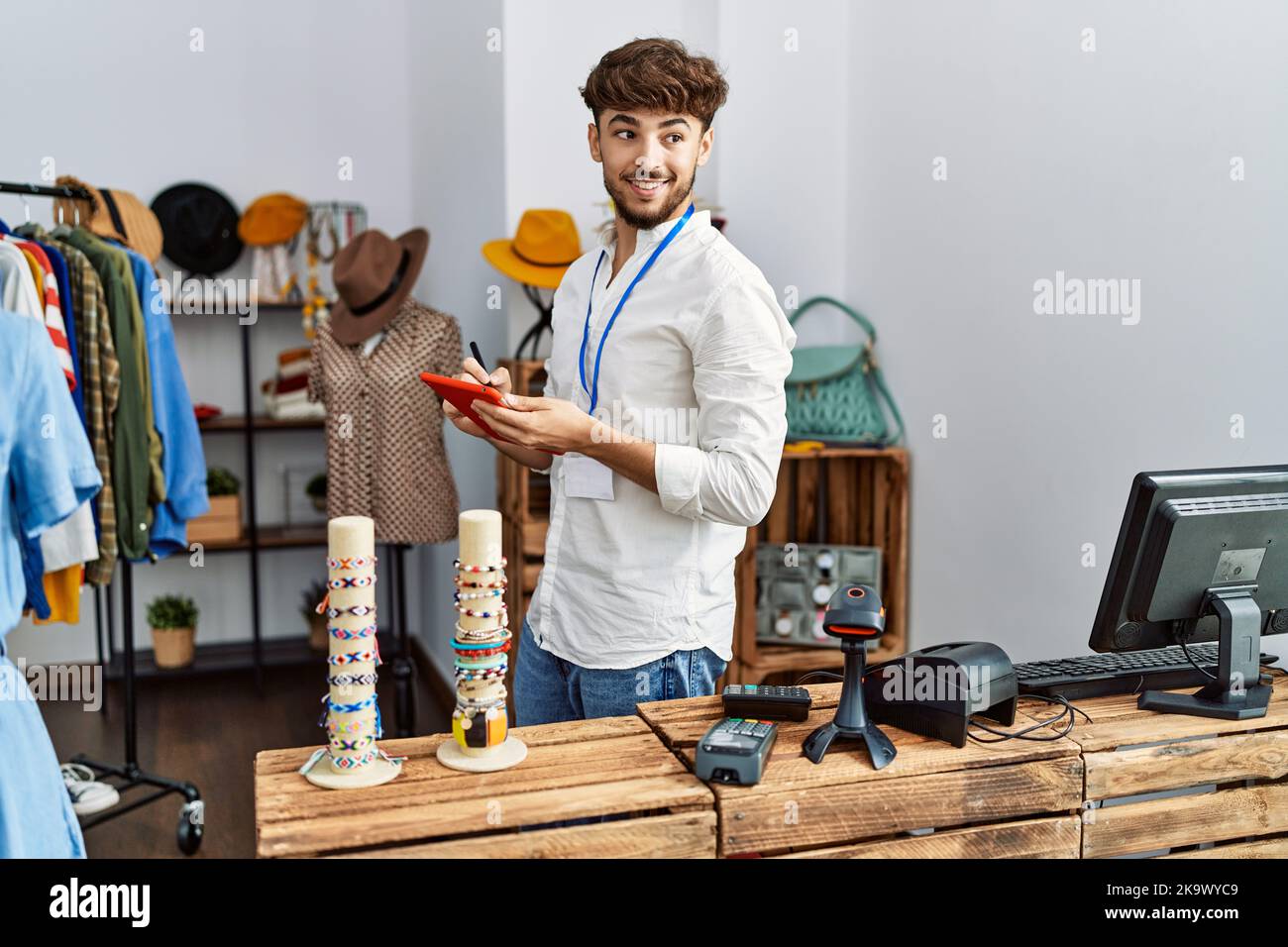 Young arab man smiling confident using touchpad at clothing store Stock ...