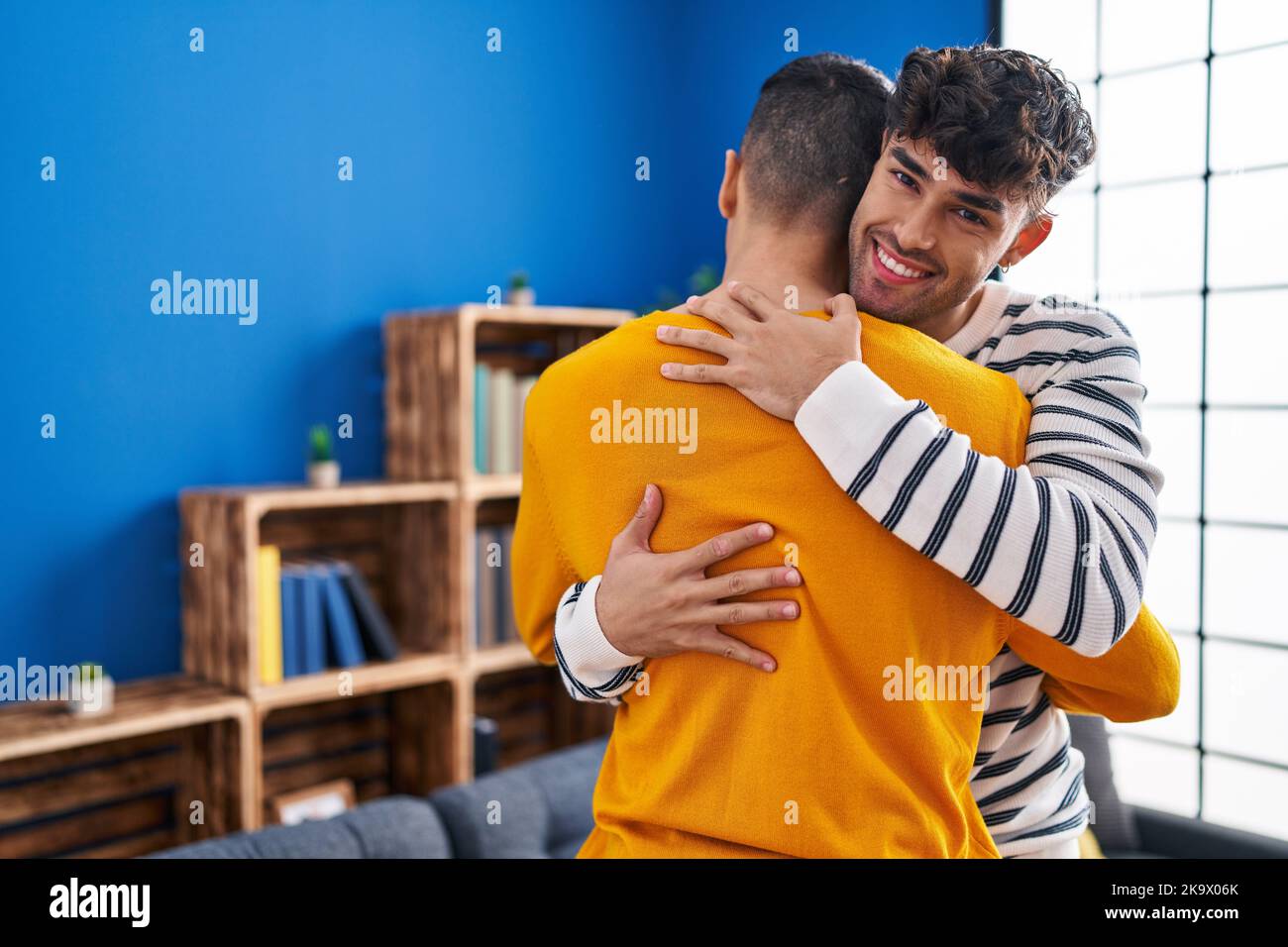 Two man couple hugging each other standing at home Stock Photo - Alamy