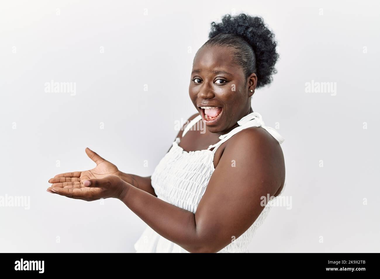Young african woman standing over white isolated background pointing ...