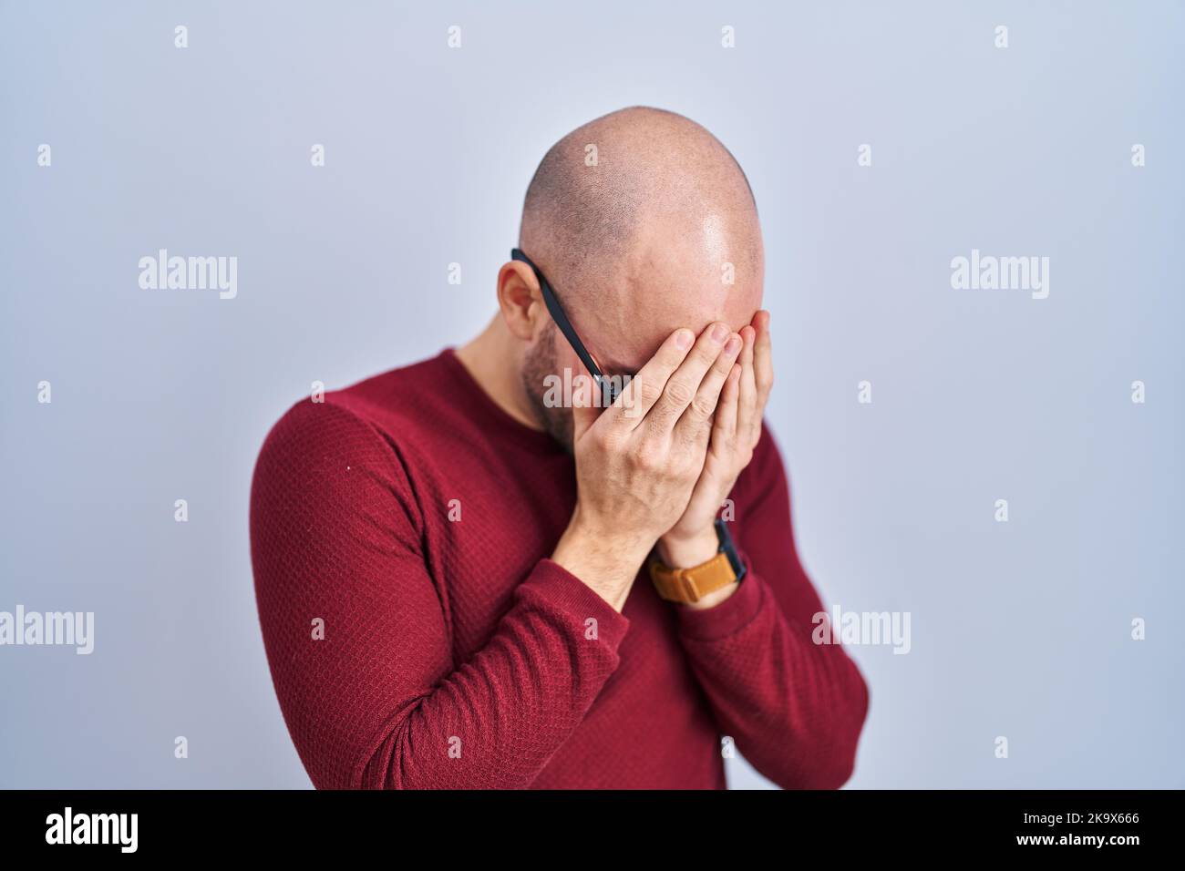 Young bald man with beard standing over white background wearing ...