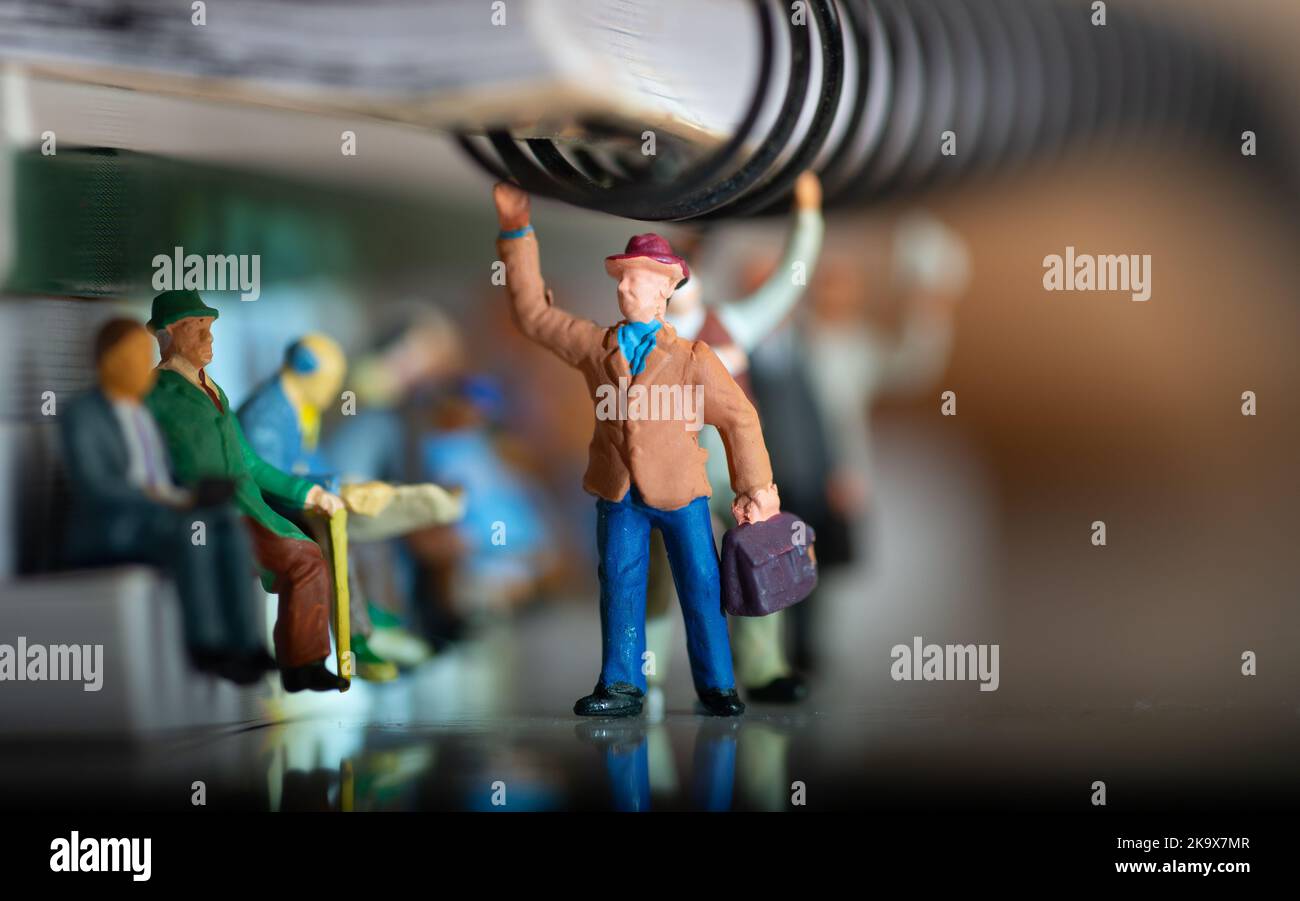 Miniature toy of people travelling on a public transport concept with shallow depth of field - travel on a train or bus. Stock Photo