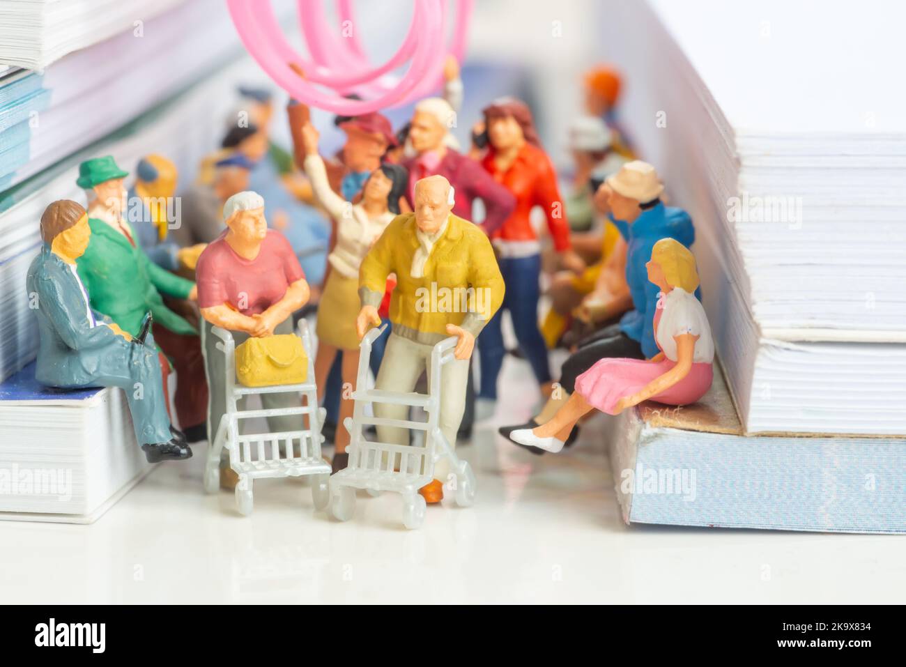 Miniature toy of couple of senior citizen on a public transport concept - travel on a train or bus. Stock Photo