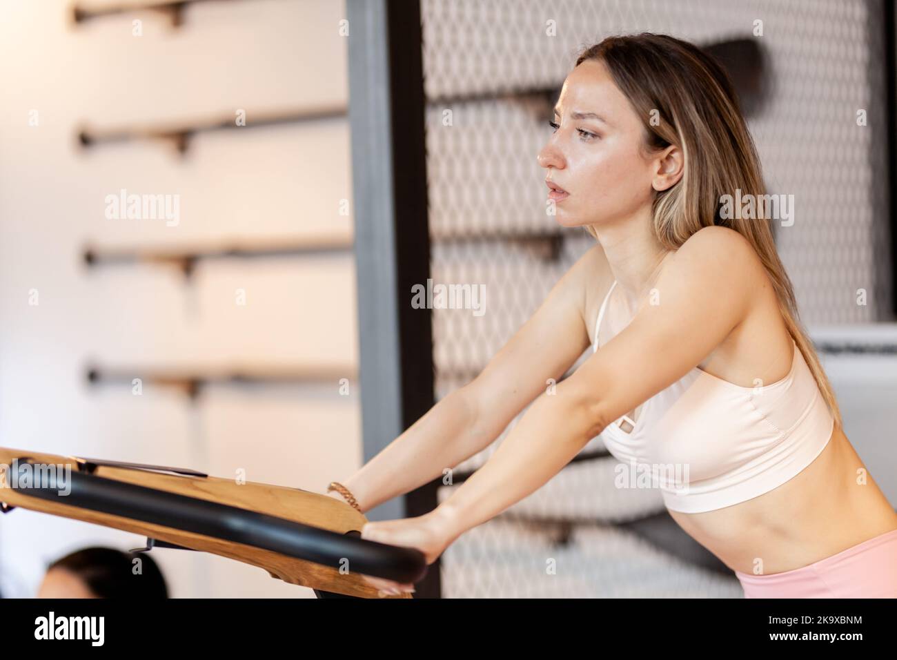 Girl exercising in on stationary bike. Fancy fitness cardio training equipment in modenr fitness center. Stock Photo