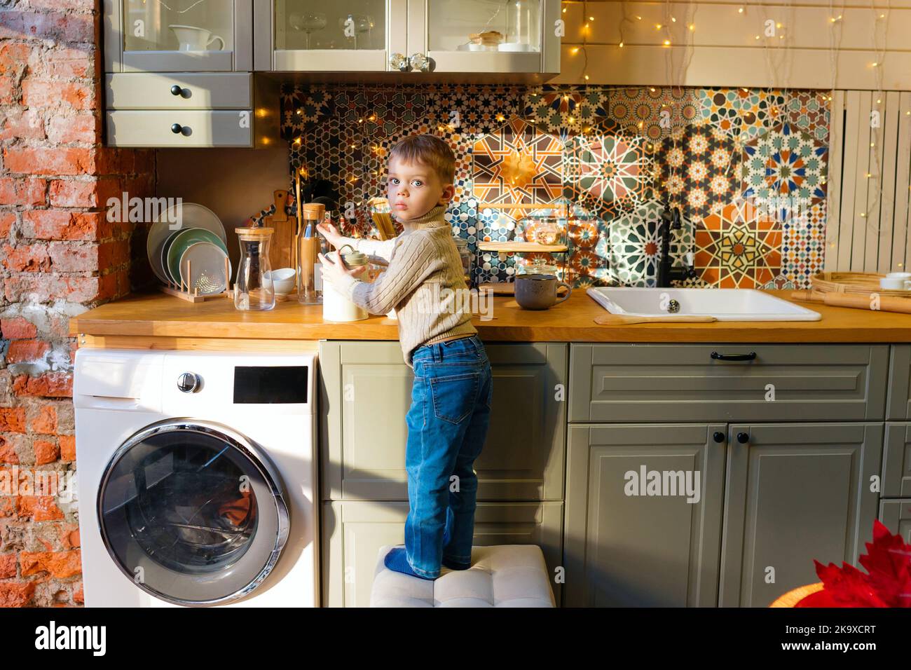Little kid helper in kitchen. Child boy 3 years old posing in kitchen ...