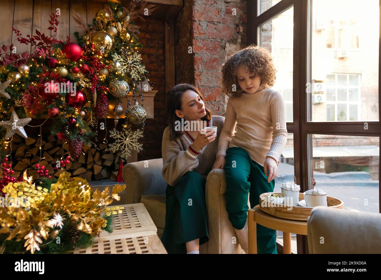 Mother and daughter enjoy Christmas morning in decorated loft style ...