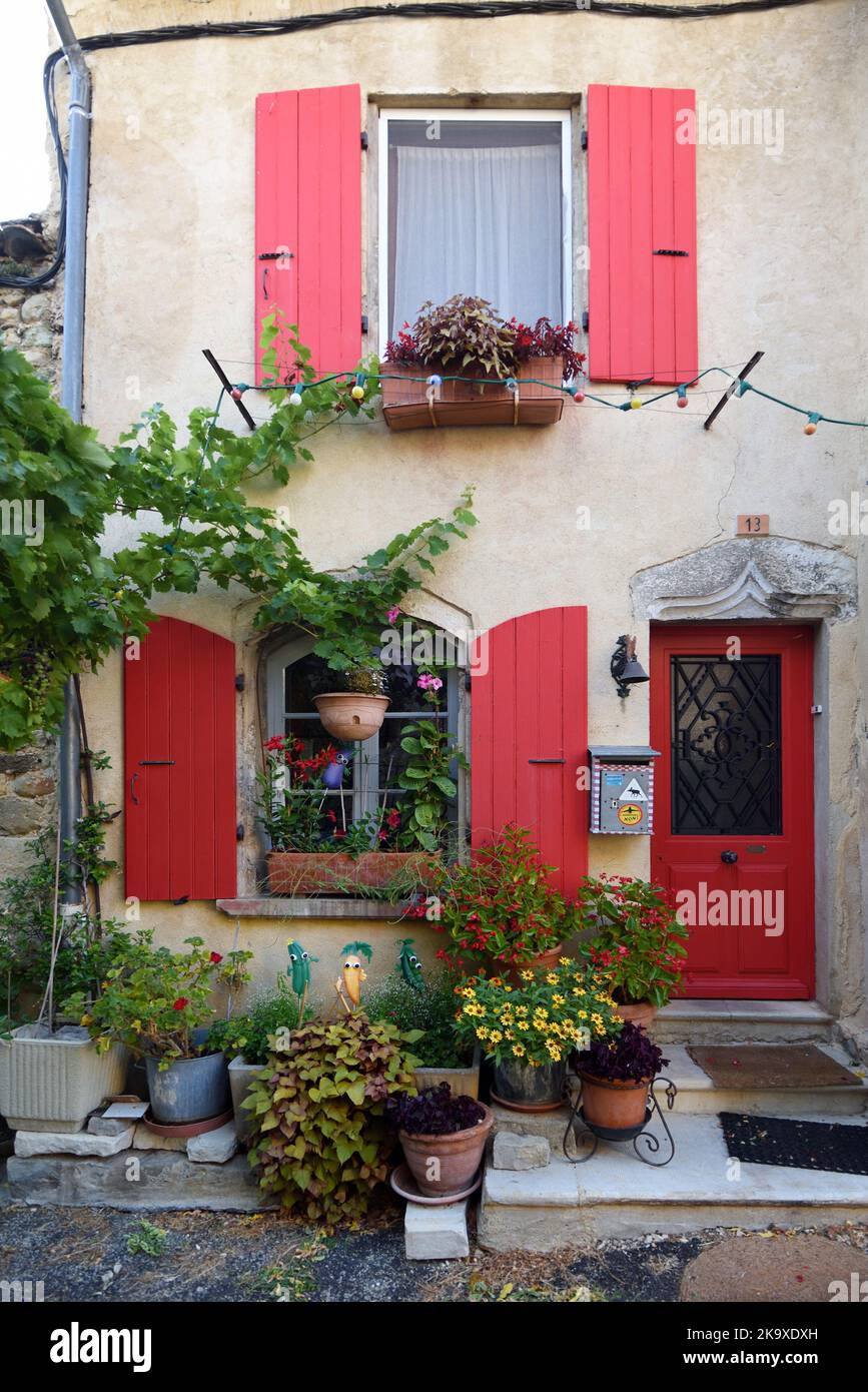 Attractive Village House with Red Shutters & Doors in the Old Town or Historic District of Dieulefit Drome France Stock Photo