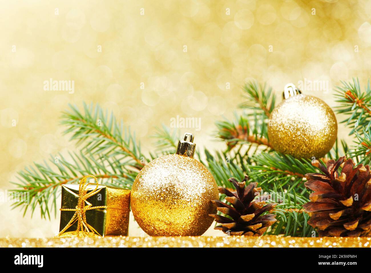 Christmas card with fir branch and decorations on golden gitter ...
