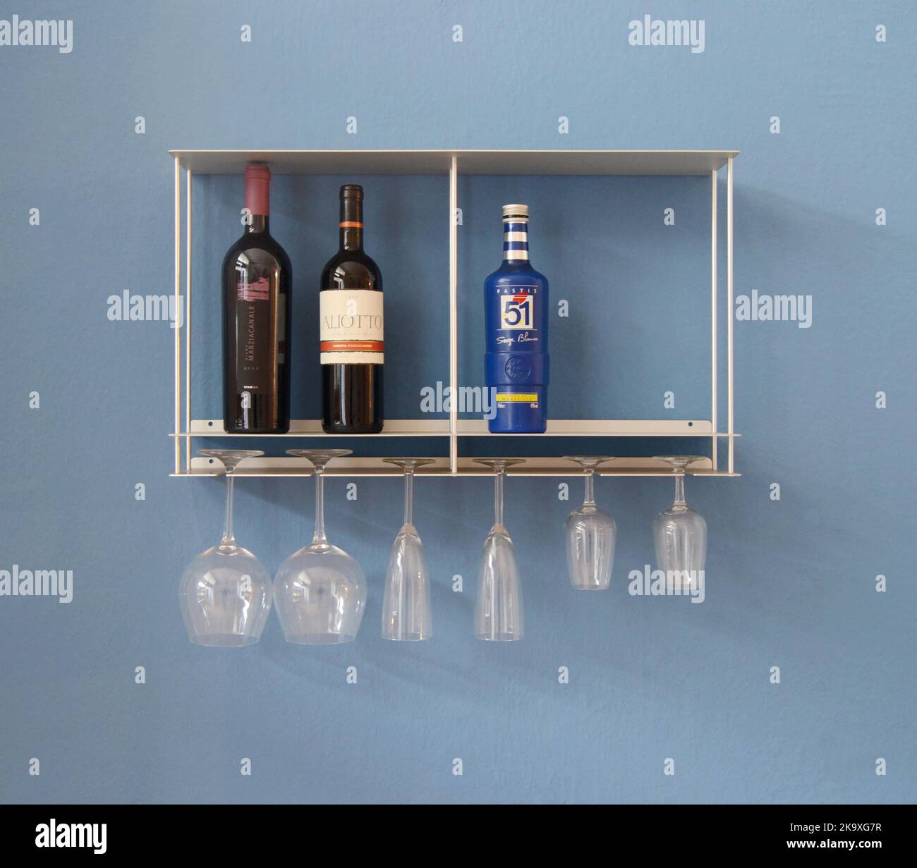 Shelving unit with wine bottles and glasses in kitchen interior Stock