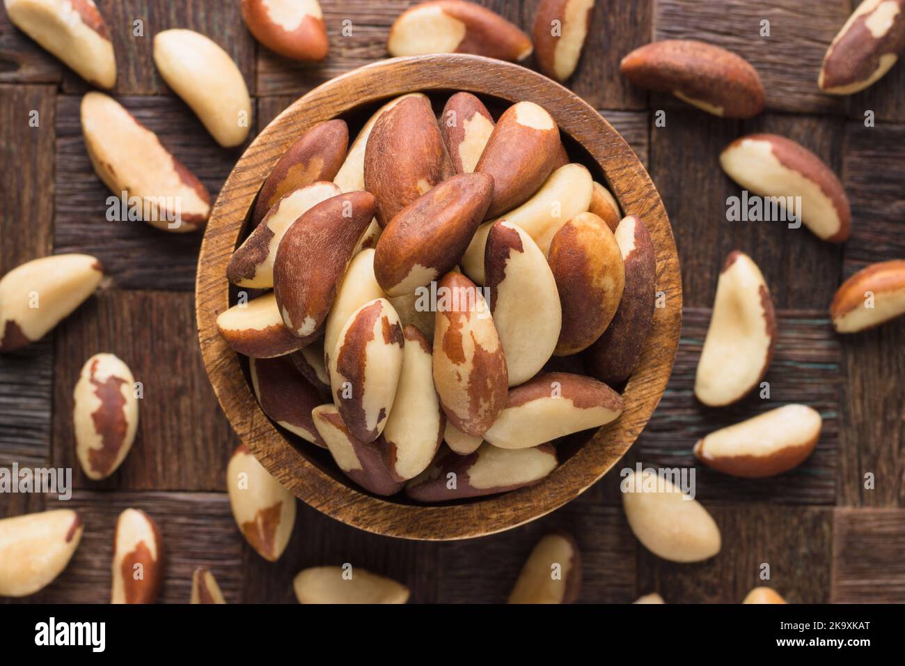 brazilian nuts peeled in bowl on wooden table background. Stock Photo