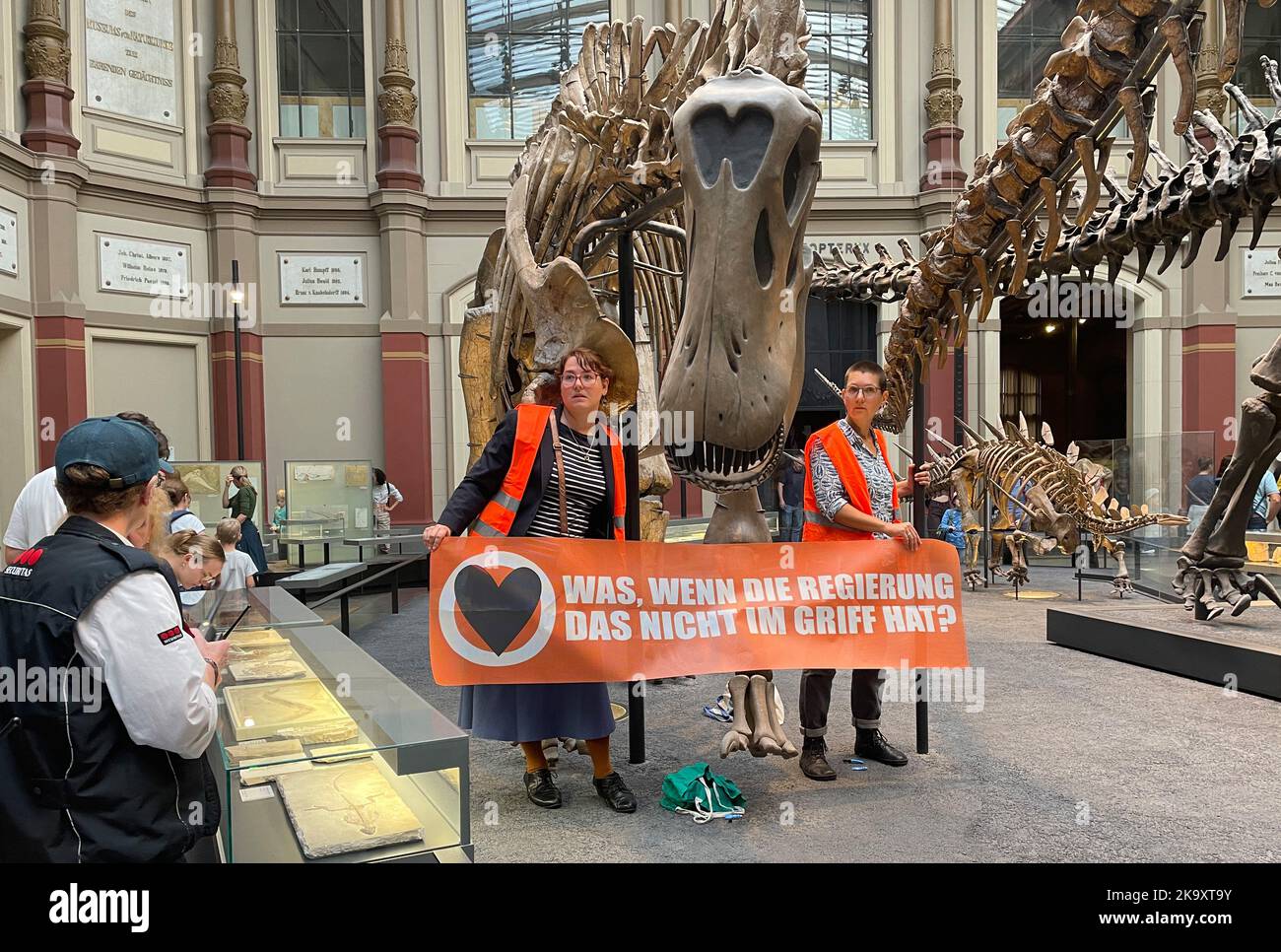 Berlin, Germany. 30th Oct, 2022. Two climate activists carrying a banner 'What if the government can't handle it?' have stuck themselves to the handrails of a dinosaur at Berlin's Museum of Natural History. Commenting on the action, the 'Last Generation' protest group said, 'Just as the dinosaurs did back then, we are threatened with climate changes that we will not be able to withstand. If we don't want to face extinction, we must act now.' Credit: Paul Zinken/dpa/Alamy Live News Stock Photo