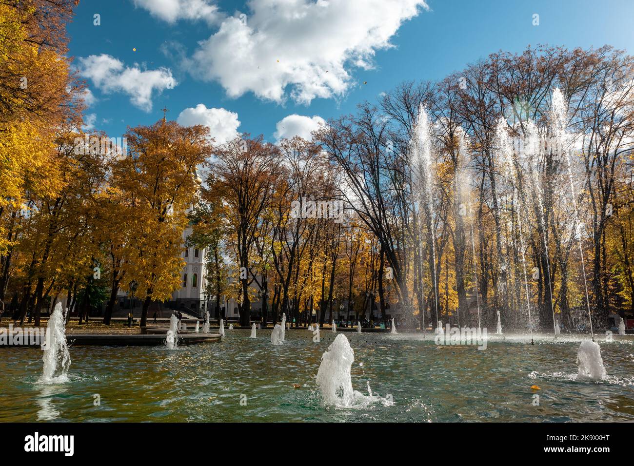Mirror Stream fountain sight near Myrrh-bearing church. Scenic autumn sunny Kharkiv city center park with blue cloudy sky, Ukraine Stock Photo